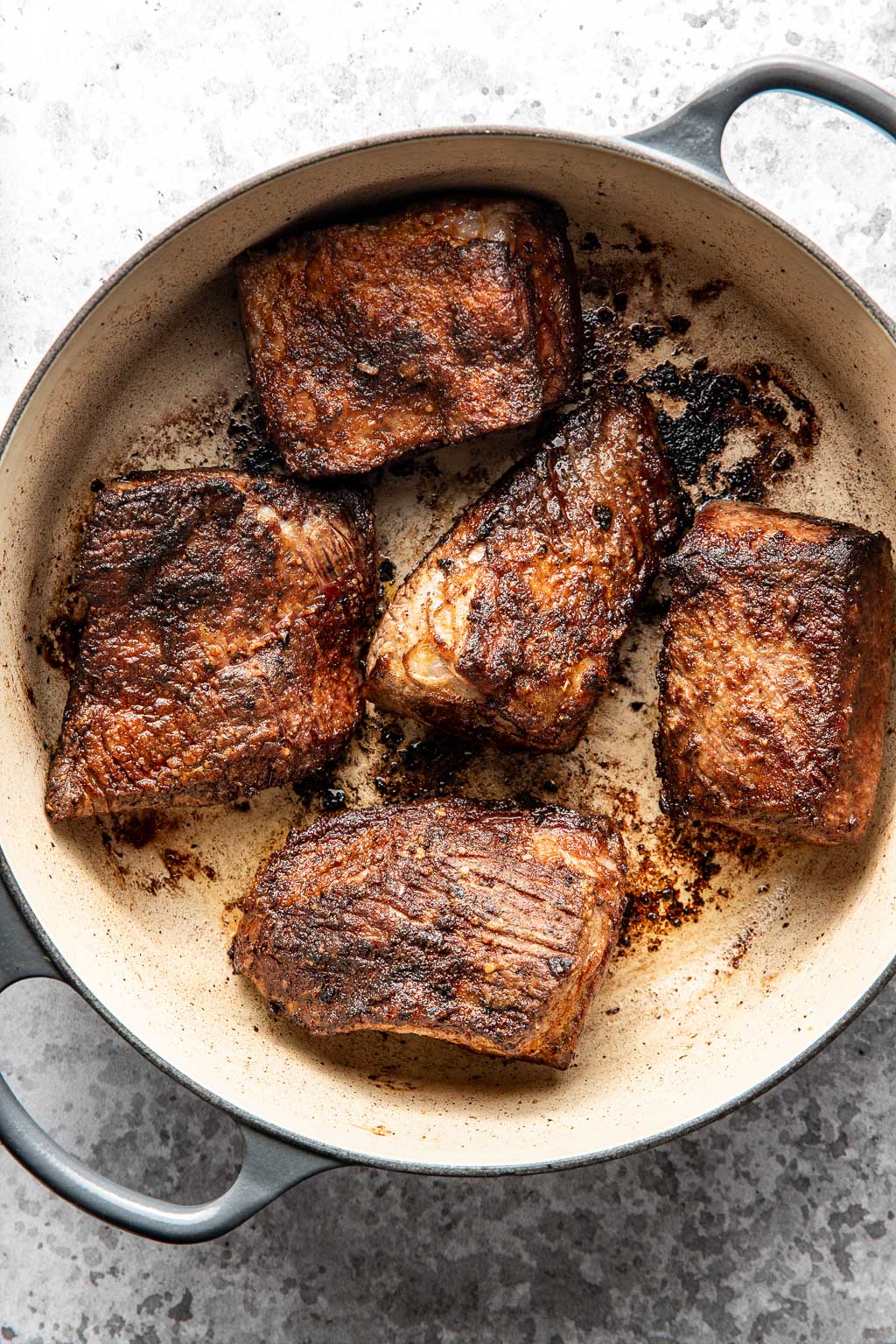 seared brisket pieces in a dutch oven