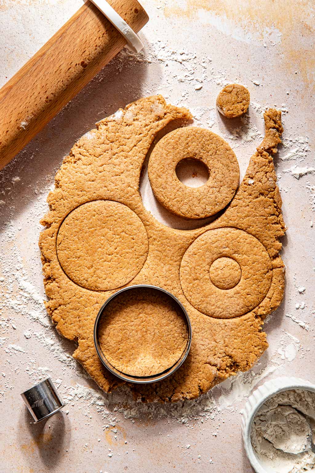 cutting out gingerbread donuts with metal rings