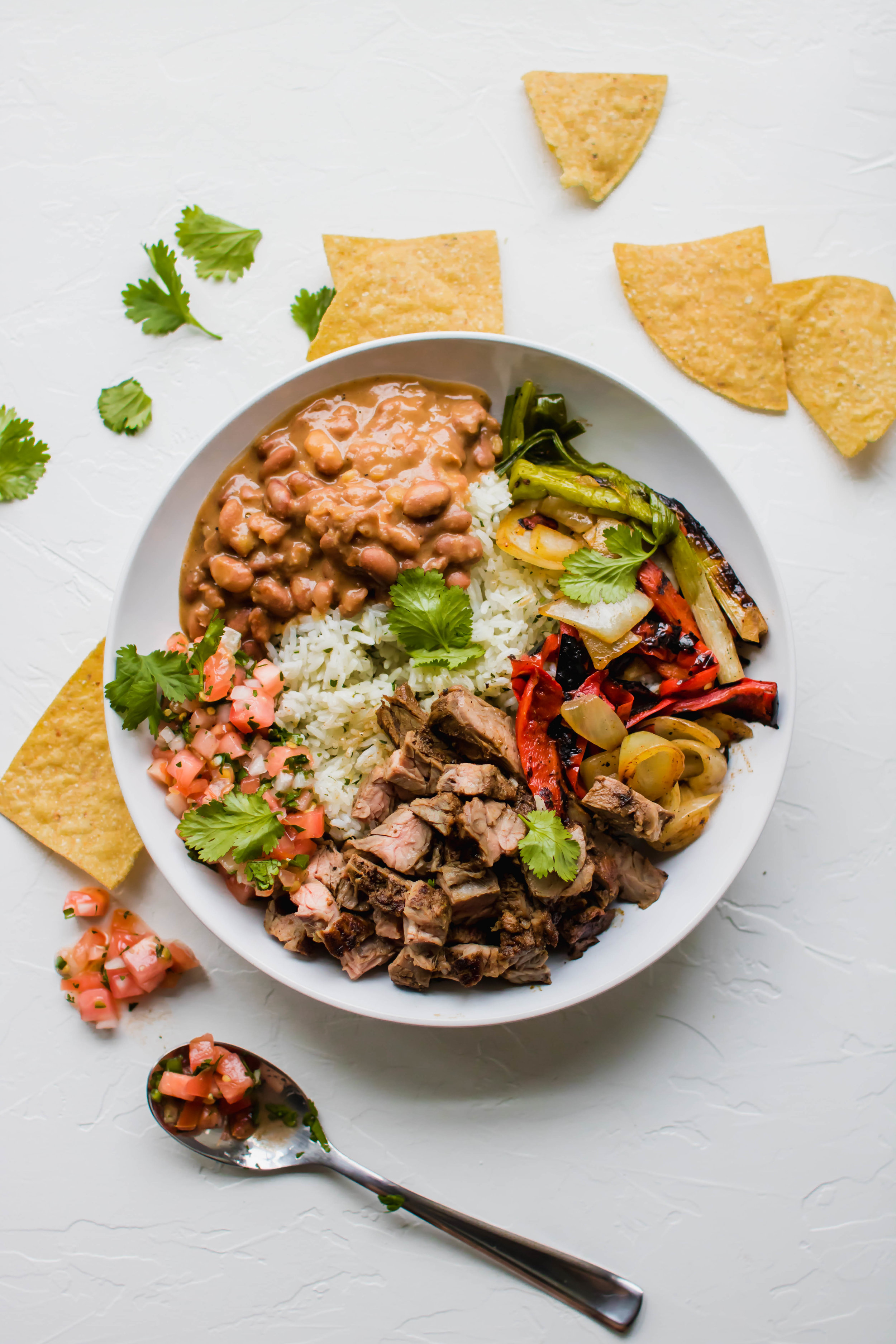 A carne asada bowl with pico de gallo and tortilla chips 