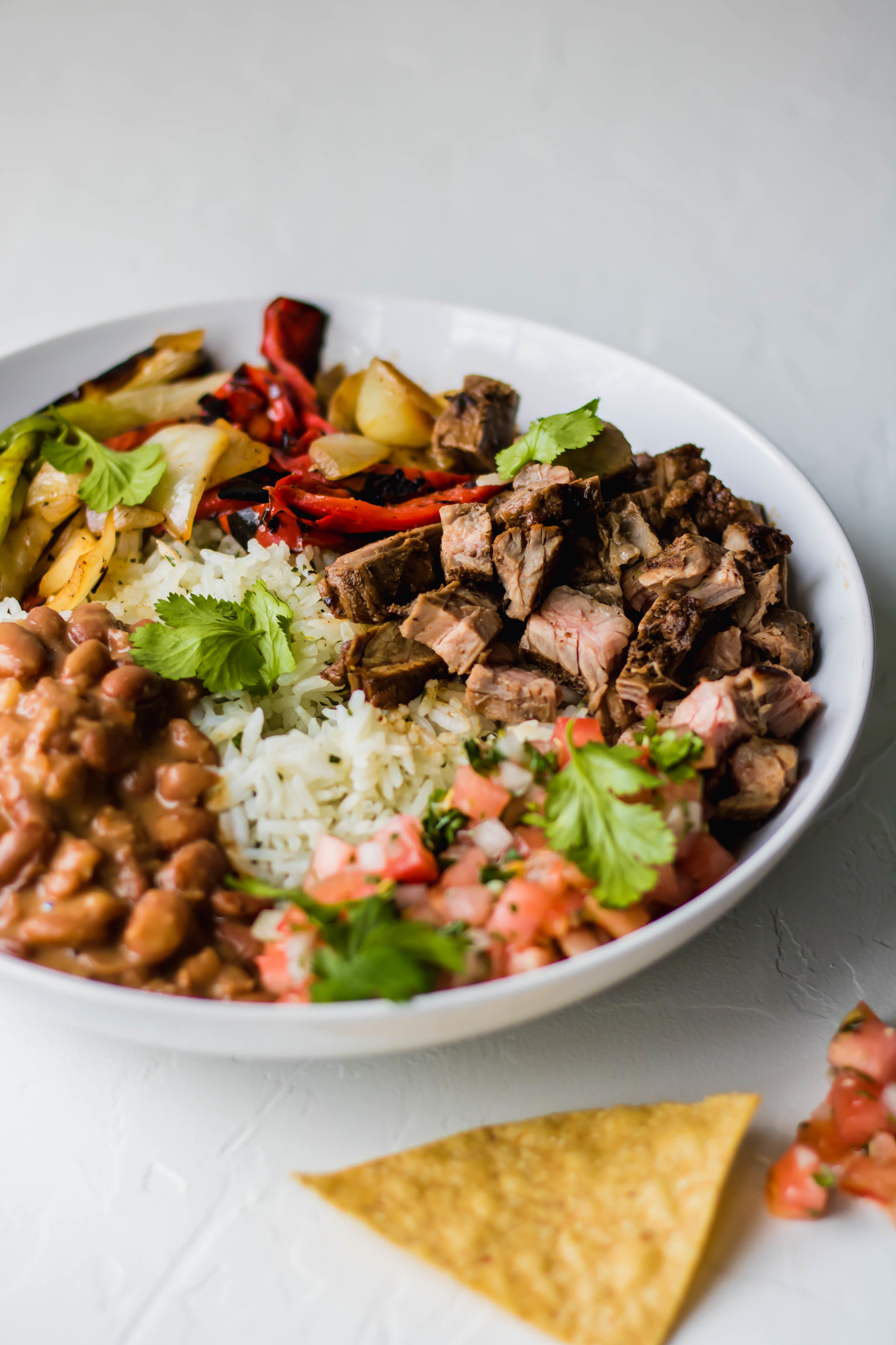 A carne asada steak bowl with tortilla chips 