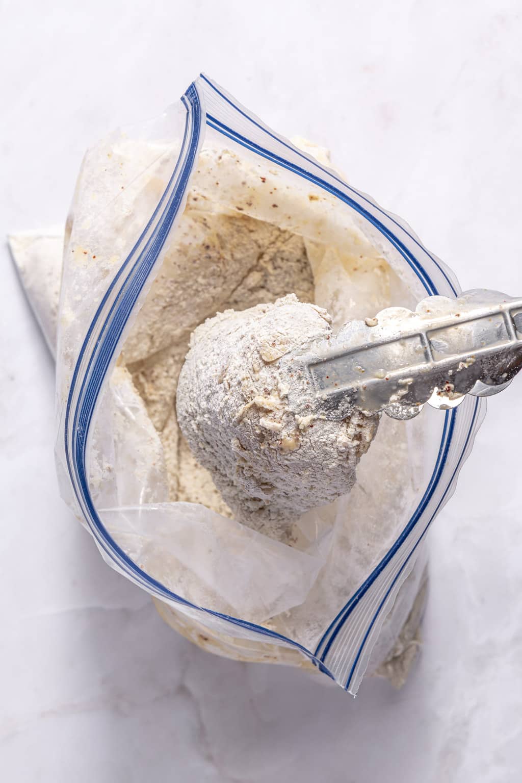 chicken coated in flour in a ziplock bag