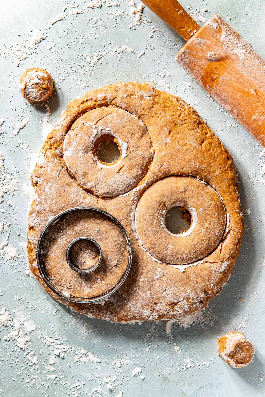 donuts being cut out on a floured surface