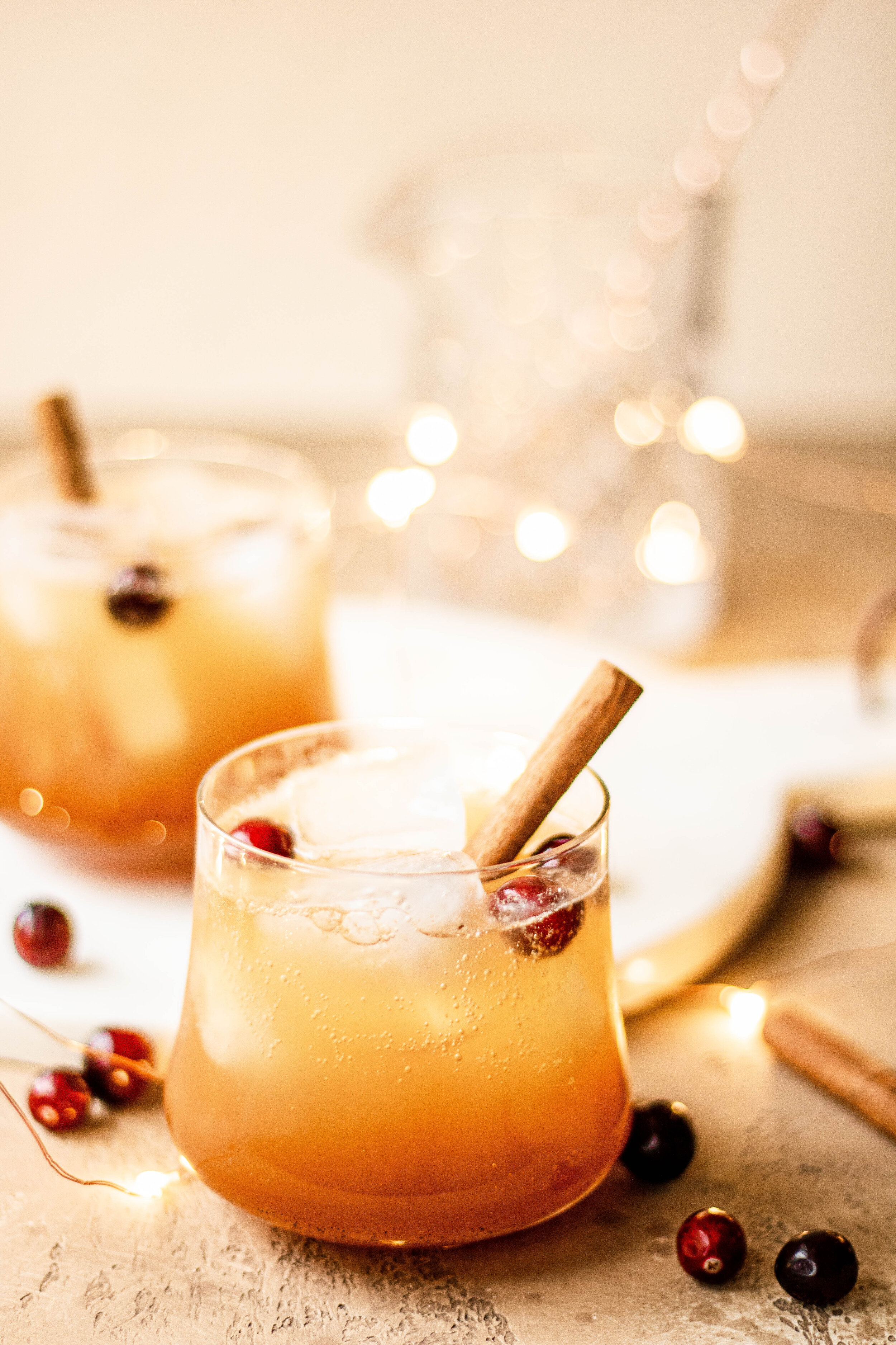 a sparkling bourbon apple cider cocktail in a glass, garnished with a cinnamon stick 
