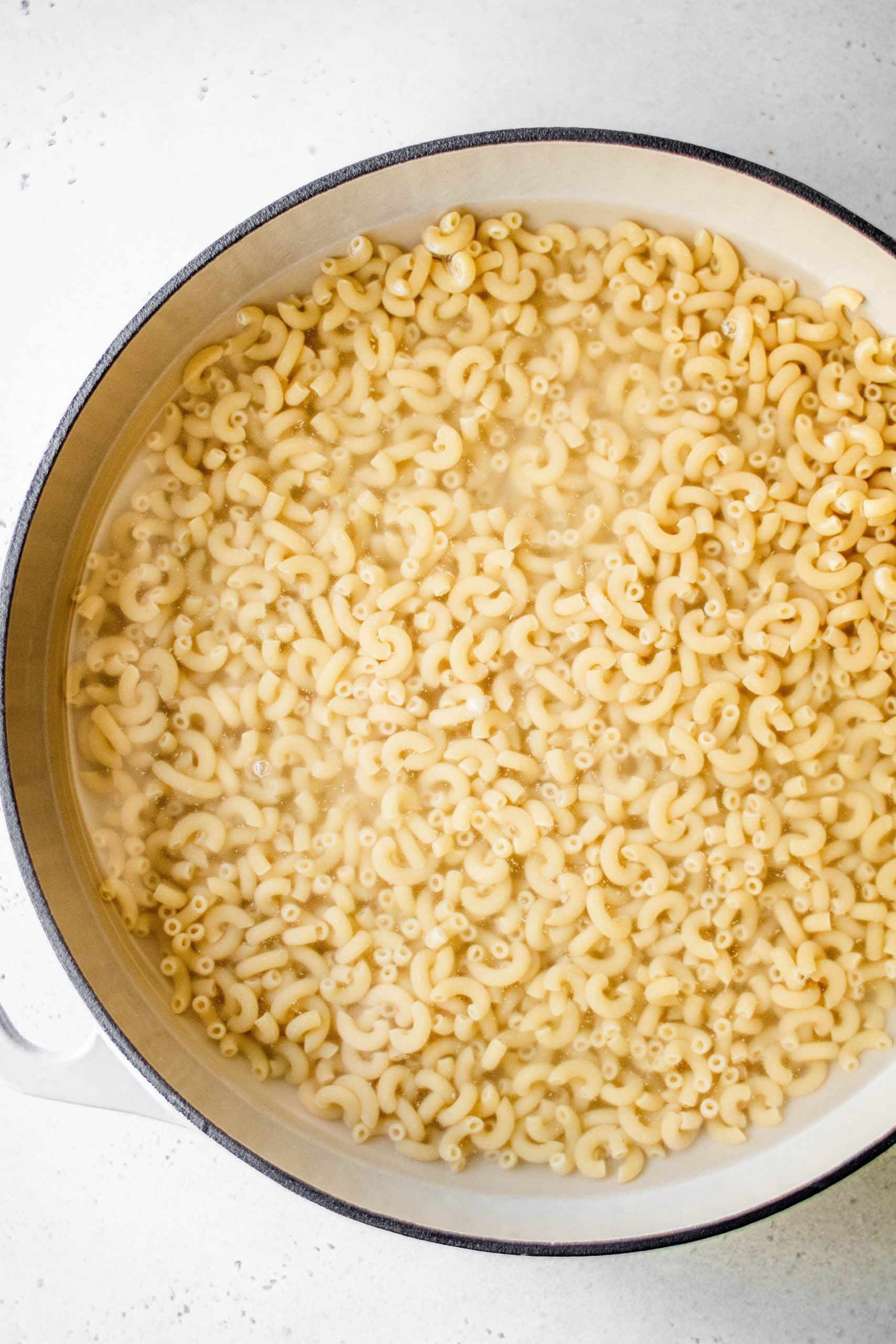 Elbow macaroni pasta submerged in water 