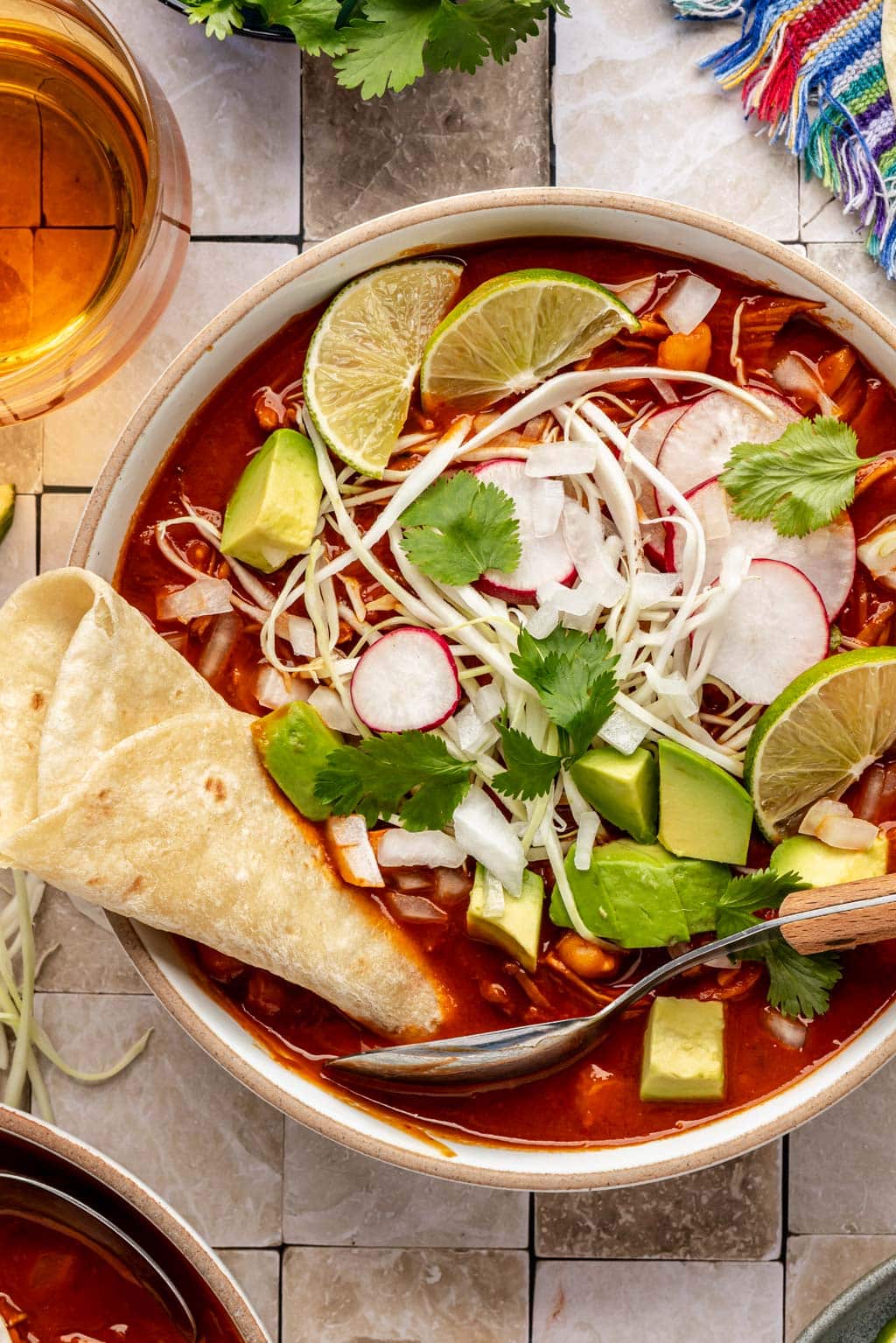 chicken pozole topped with shredded cabbage, radish, lime, and avocado 
