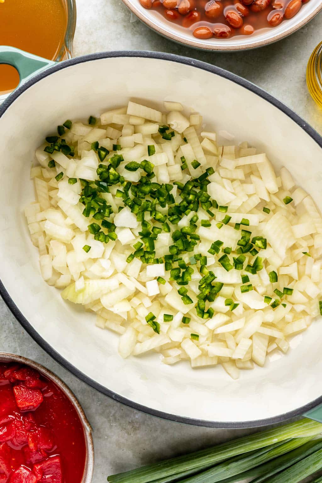 onions and jalapeno in an oval dutch oven