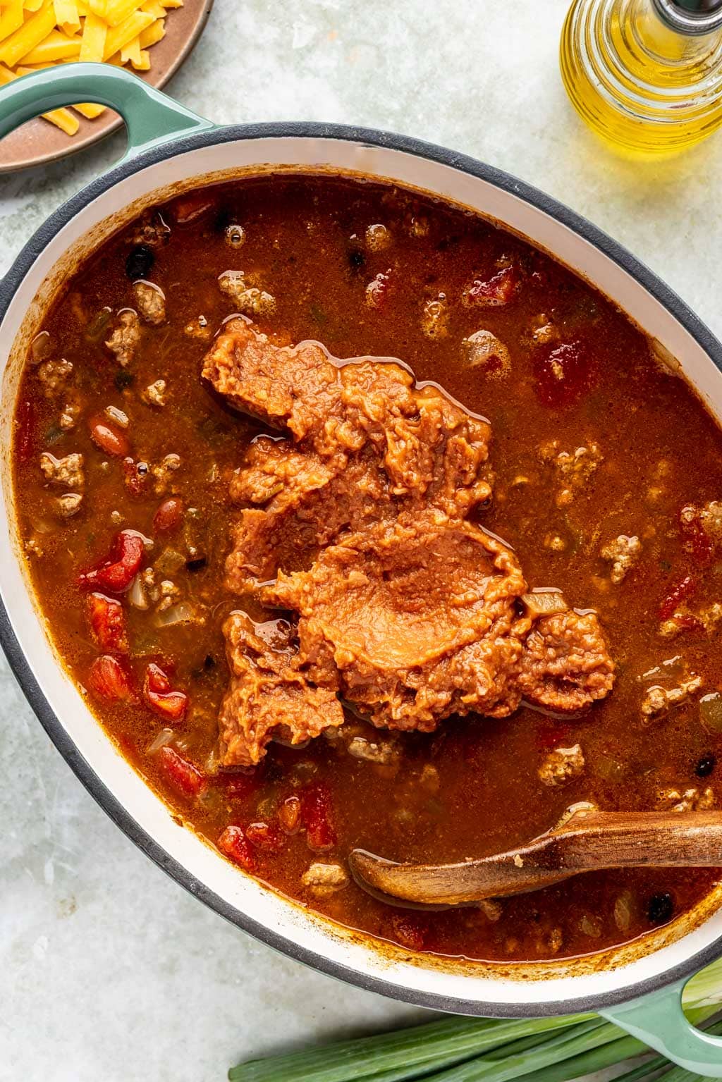 refried beans being added to the chili