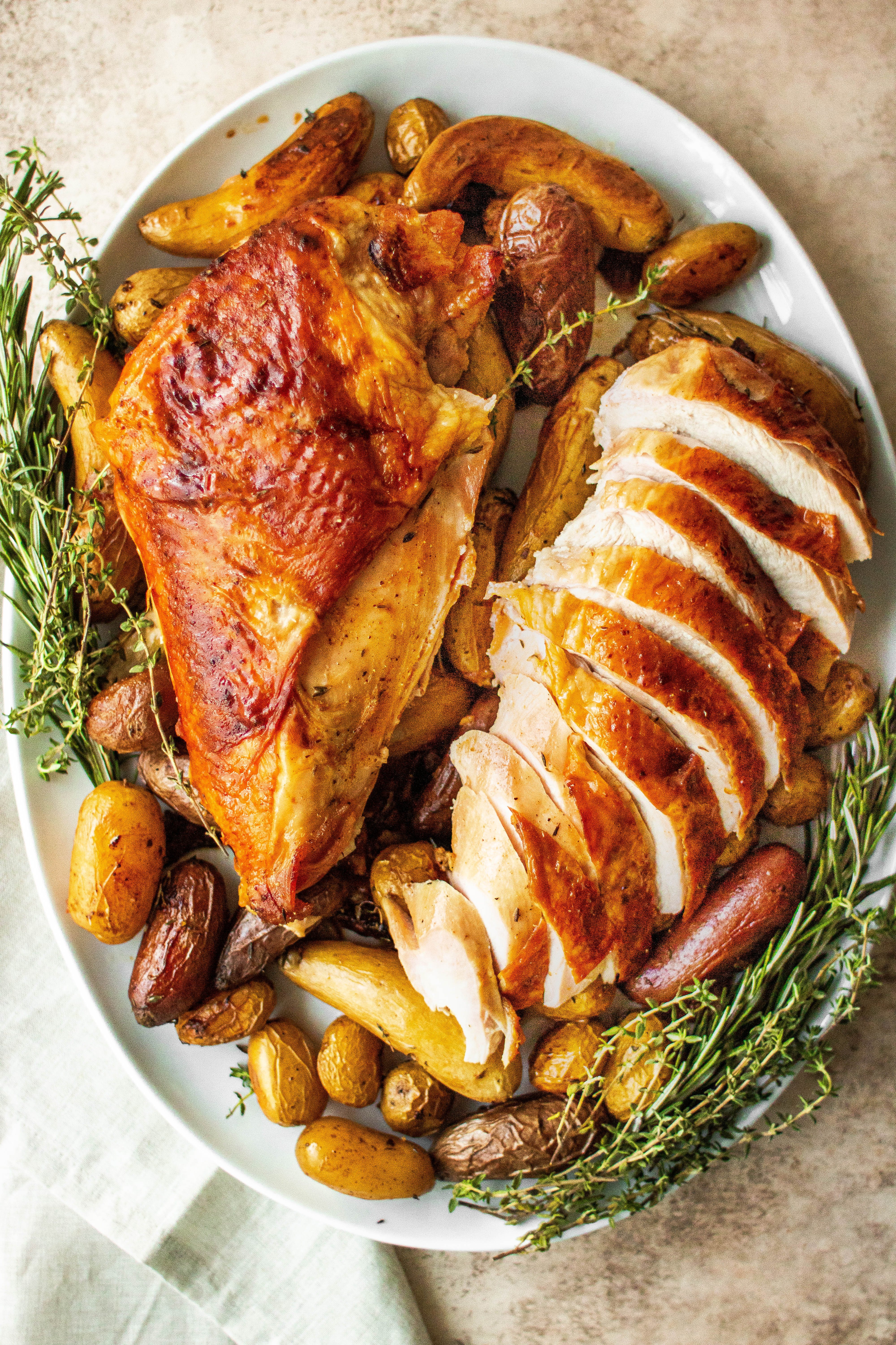 A moist roast turkey breast, partially sliced on a platter 
