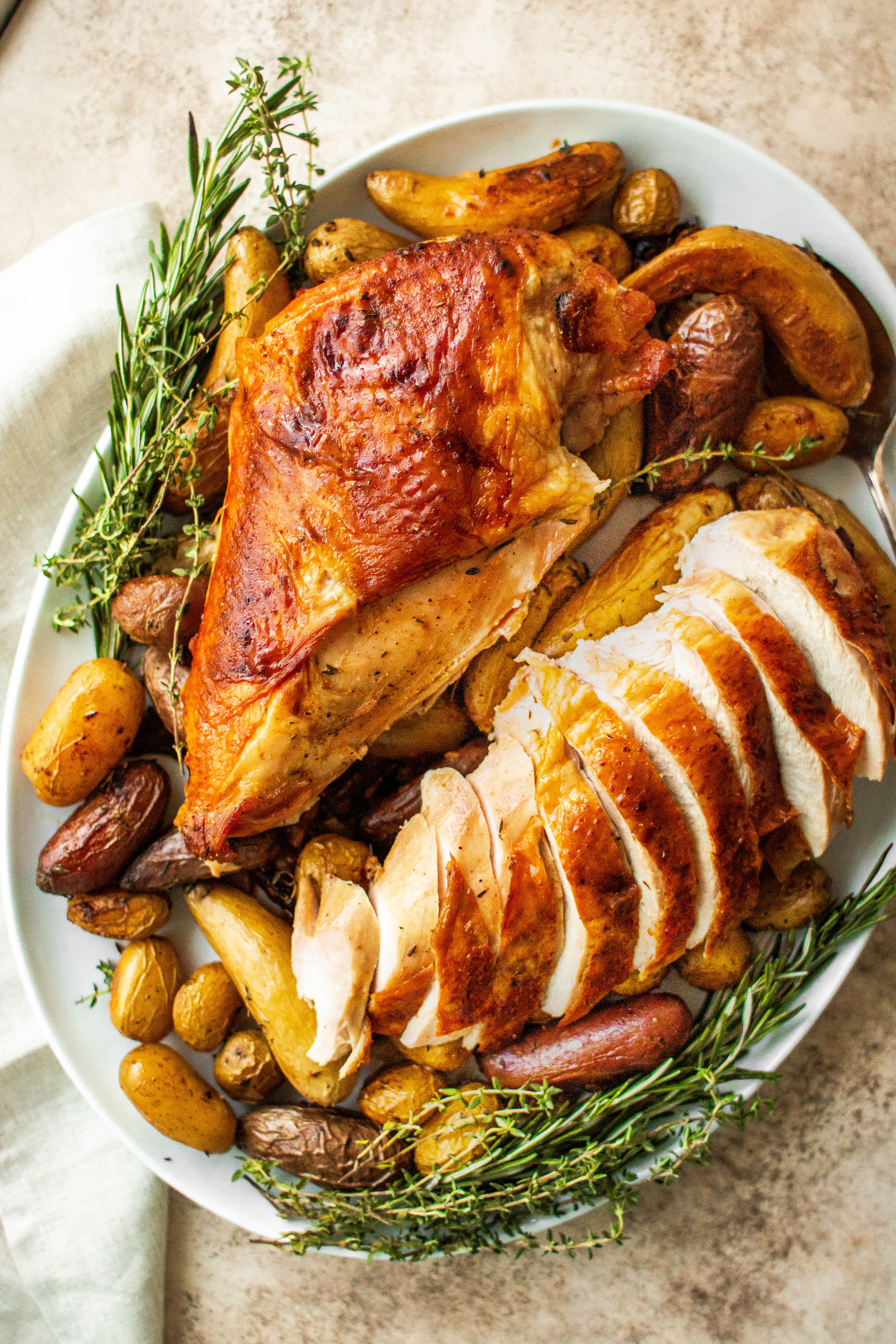 A moist roast turkey breast, partially sliced on a platter 