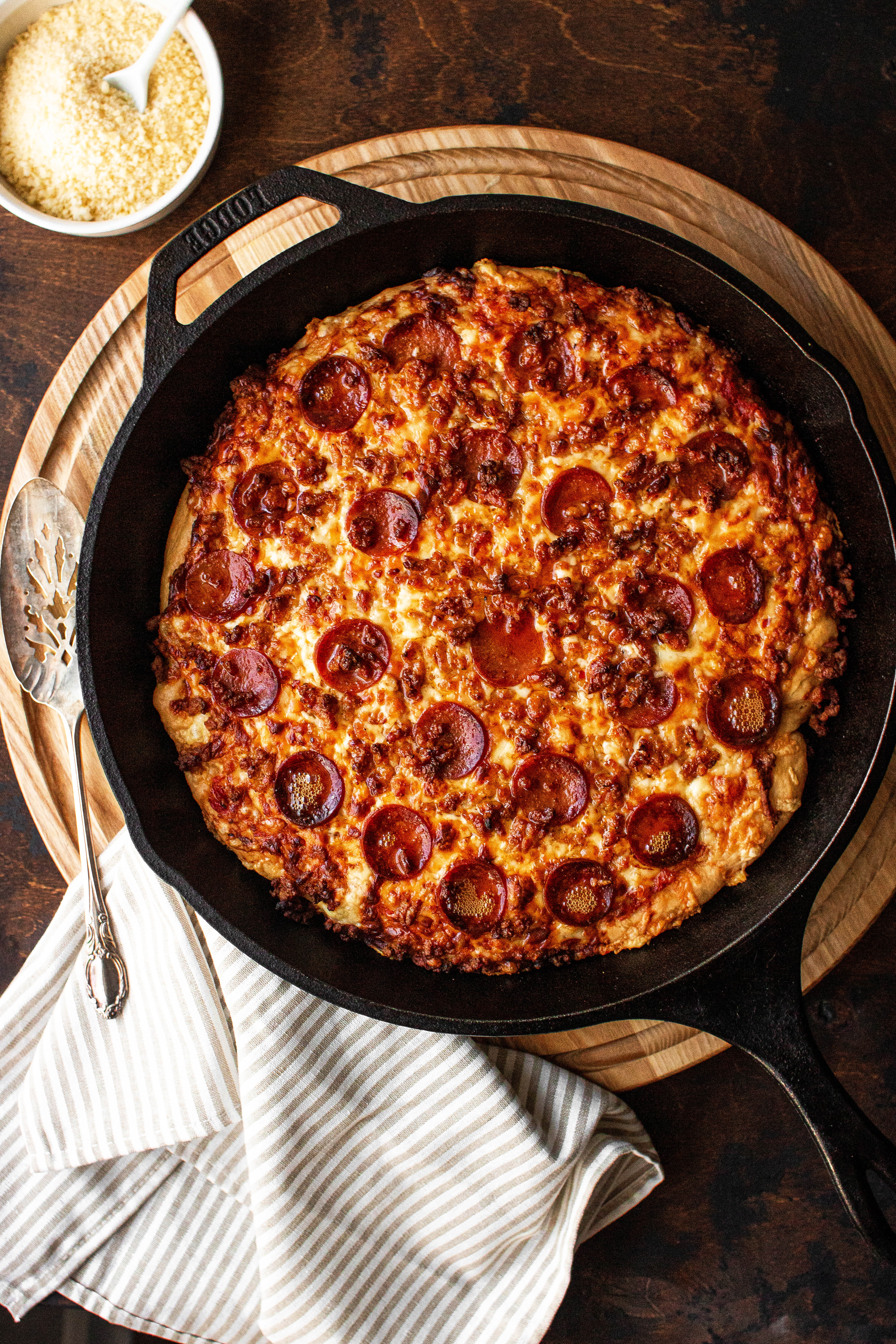 A pepperoni and sausage pizza in a cast iron skillet 