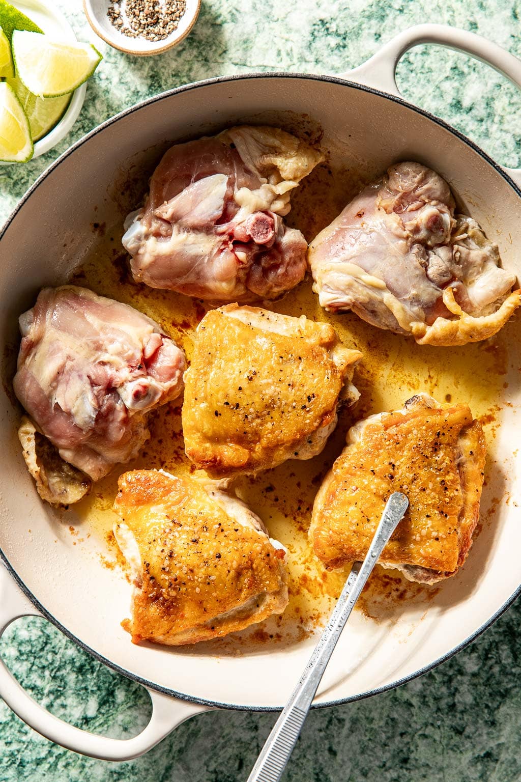 Chicken thighs being seared in a braiser