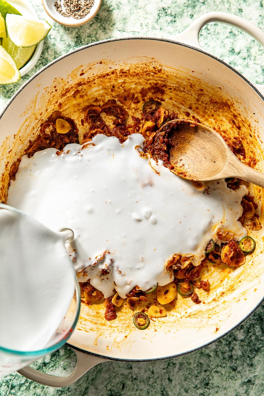 Coconut milk being poured into the braiser
