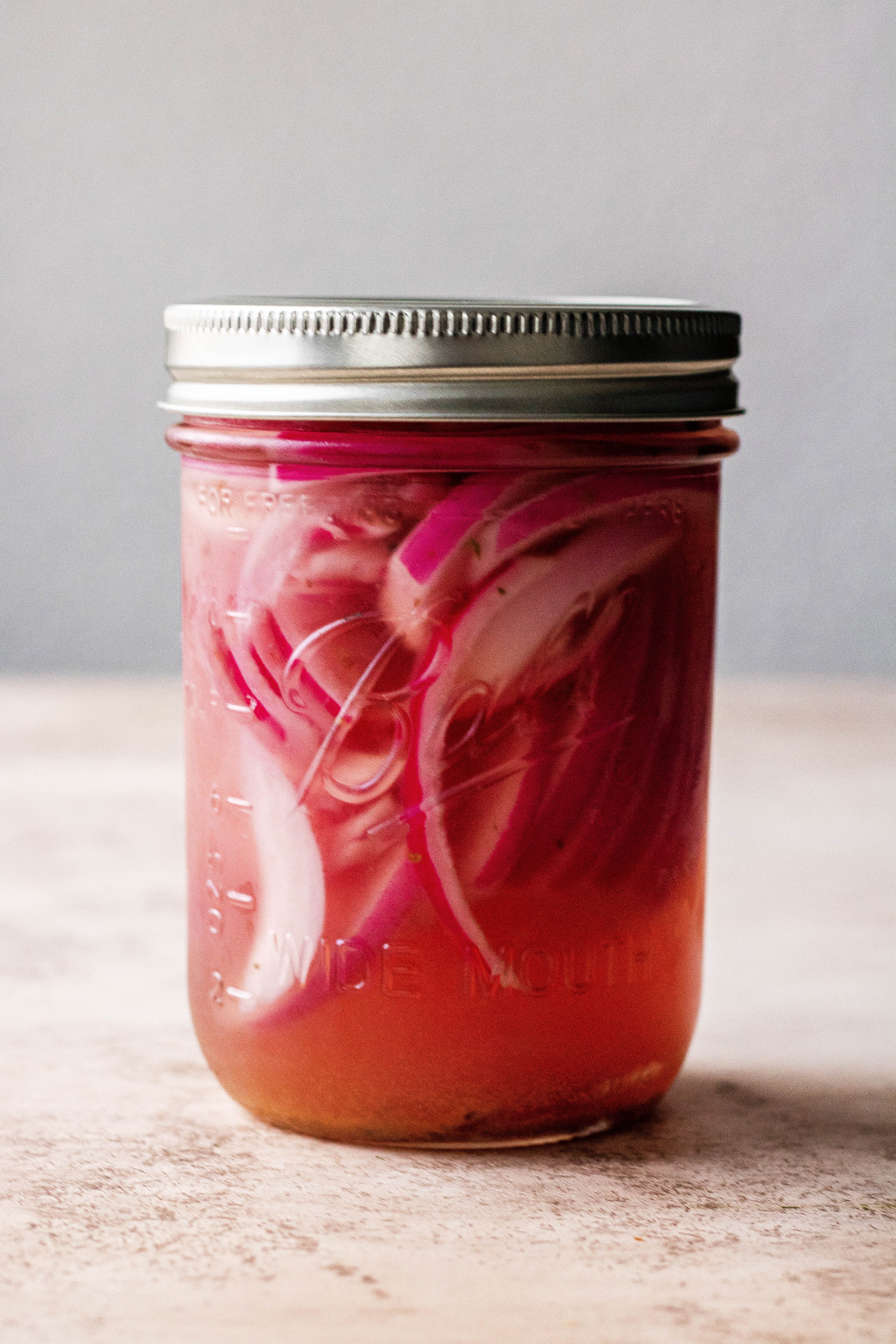 A mason jar full of pickled red onions 