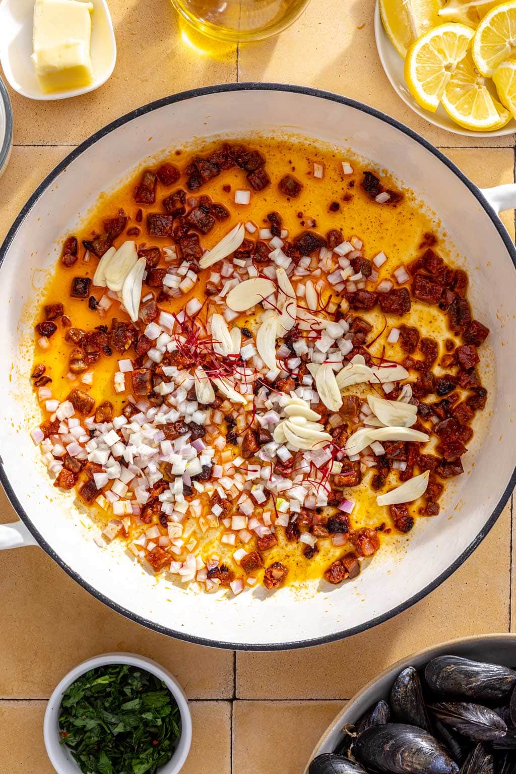 Garlic, shallot and saffron in a braiser with chorizo