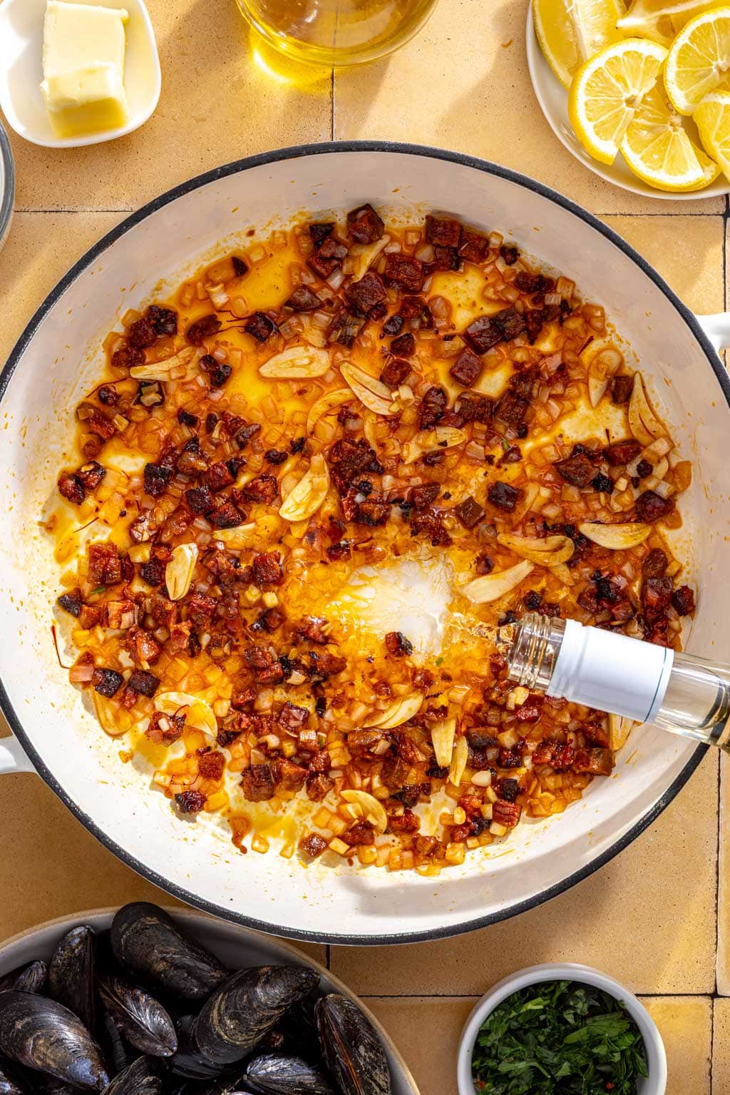 White wine being poured from the bottle into the braiser