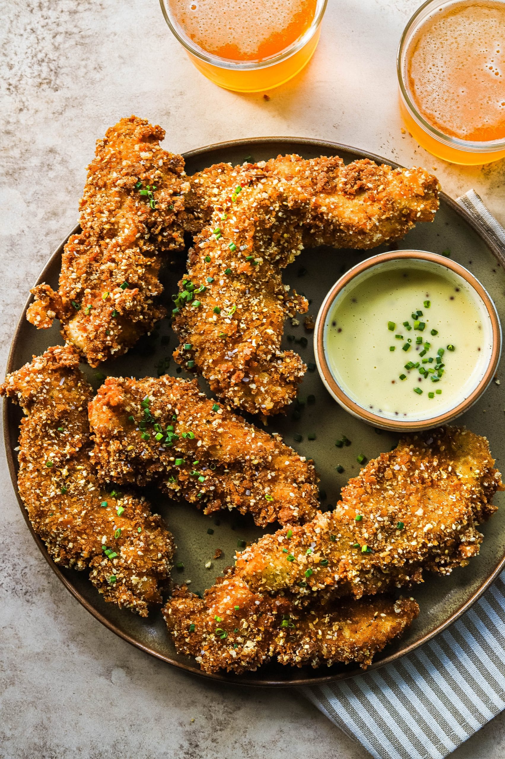 homemade fried chicken tenders on a plate with dipping sauce 