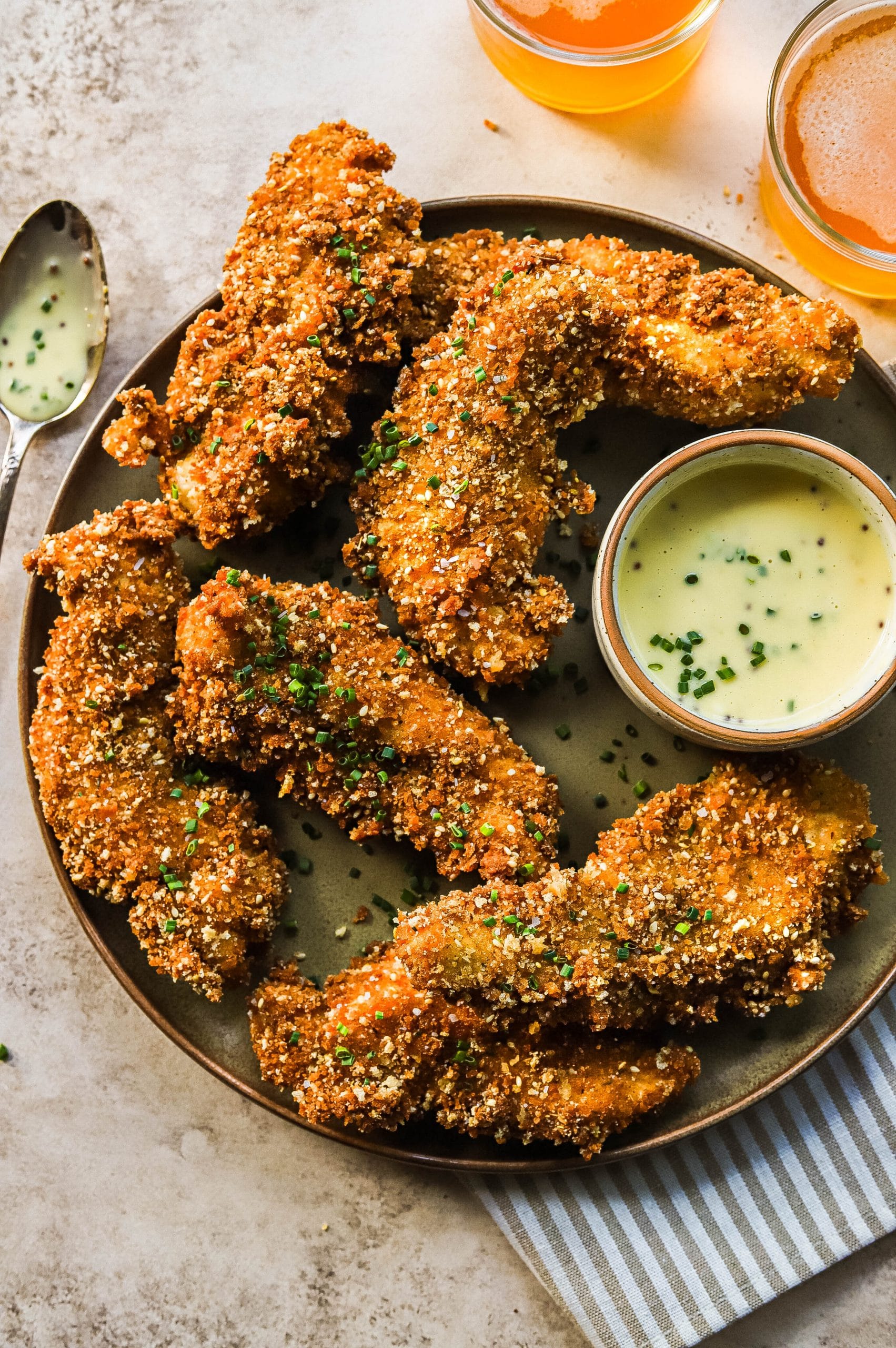 homemade fried chicken tenders on a plate with dipping sauce 