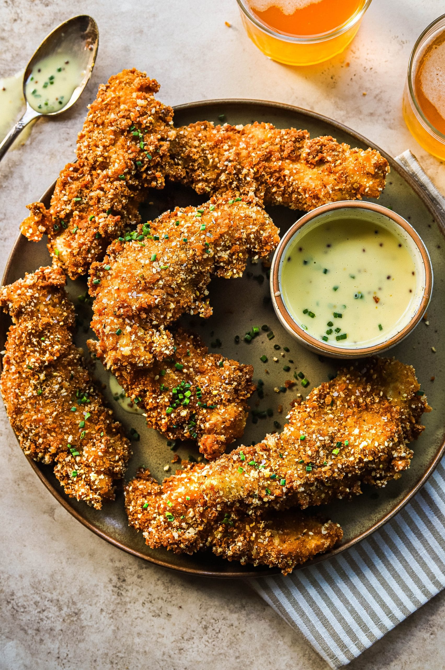homemade fried chicken tenders on a plate with dipping sauce 