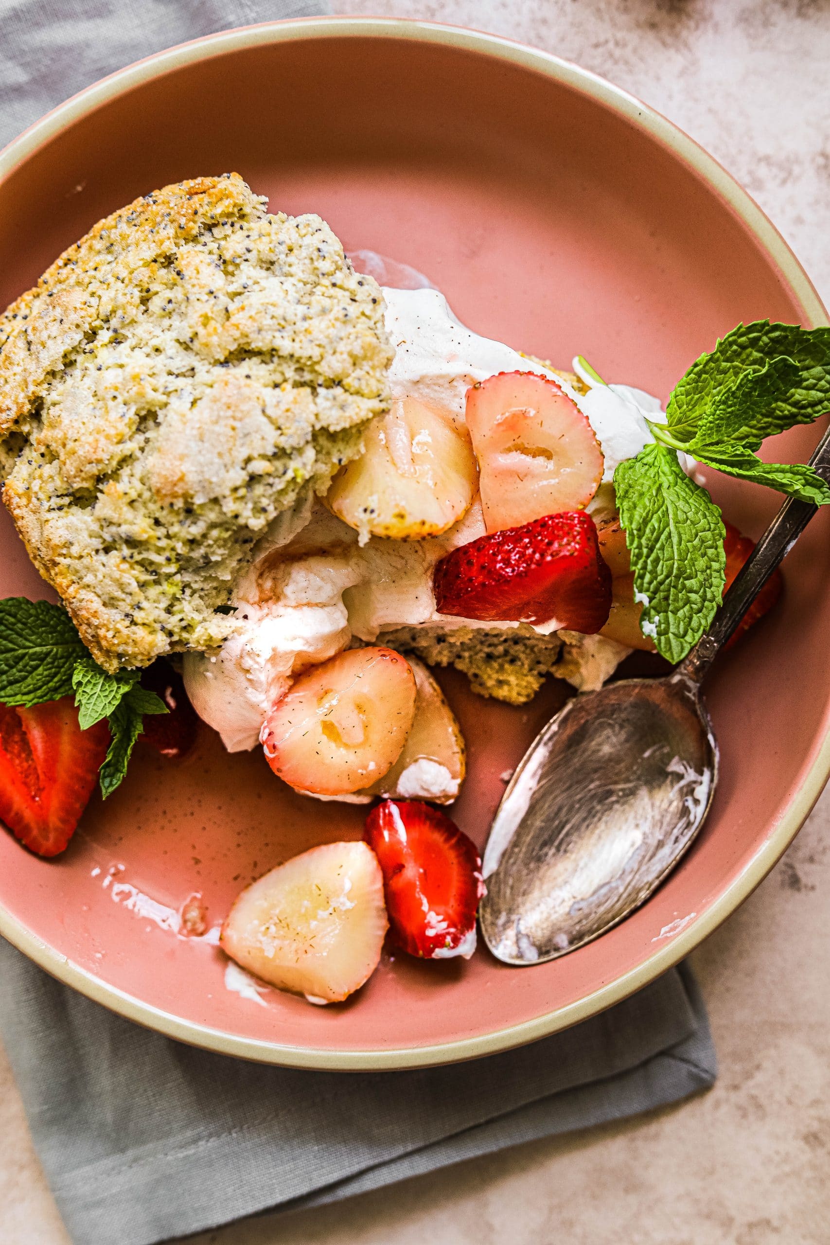 Strawberry lemon shortcake on a pink plate, with a bite missing 