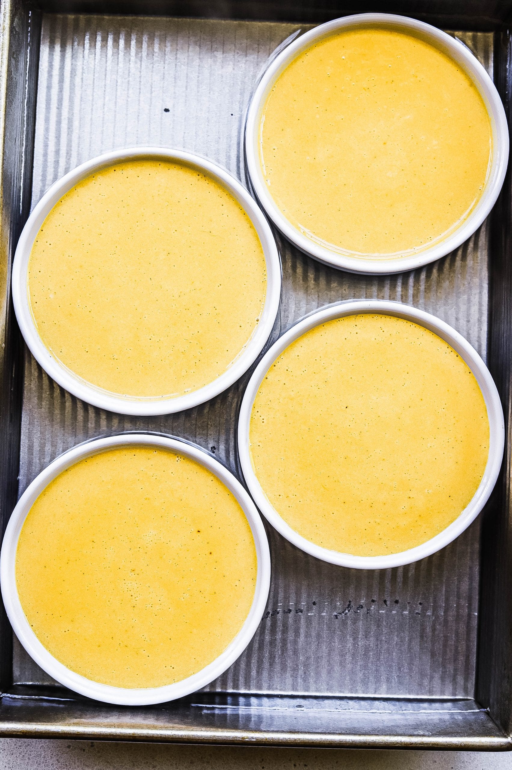 Uncooked pumpkin spice crème brûlée mixture in ramekins 