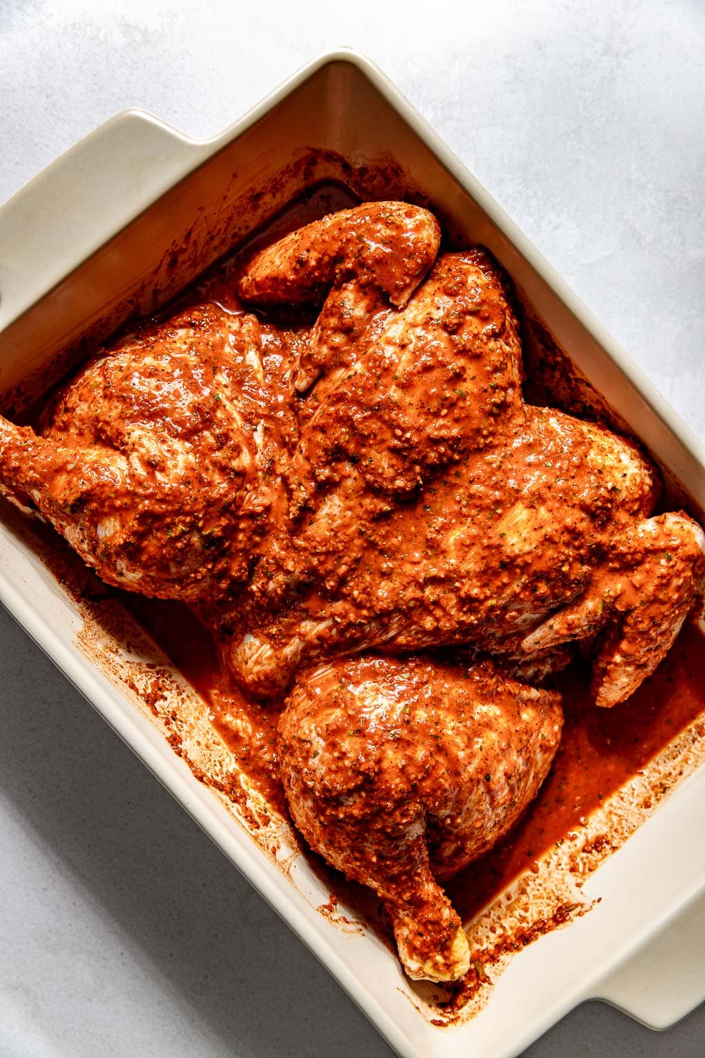 Chicken marinating in a baking dish