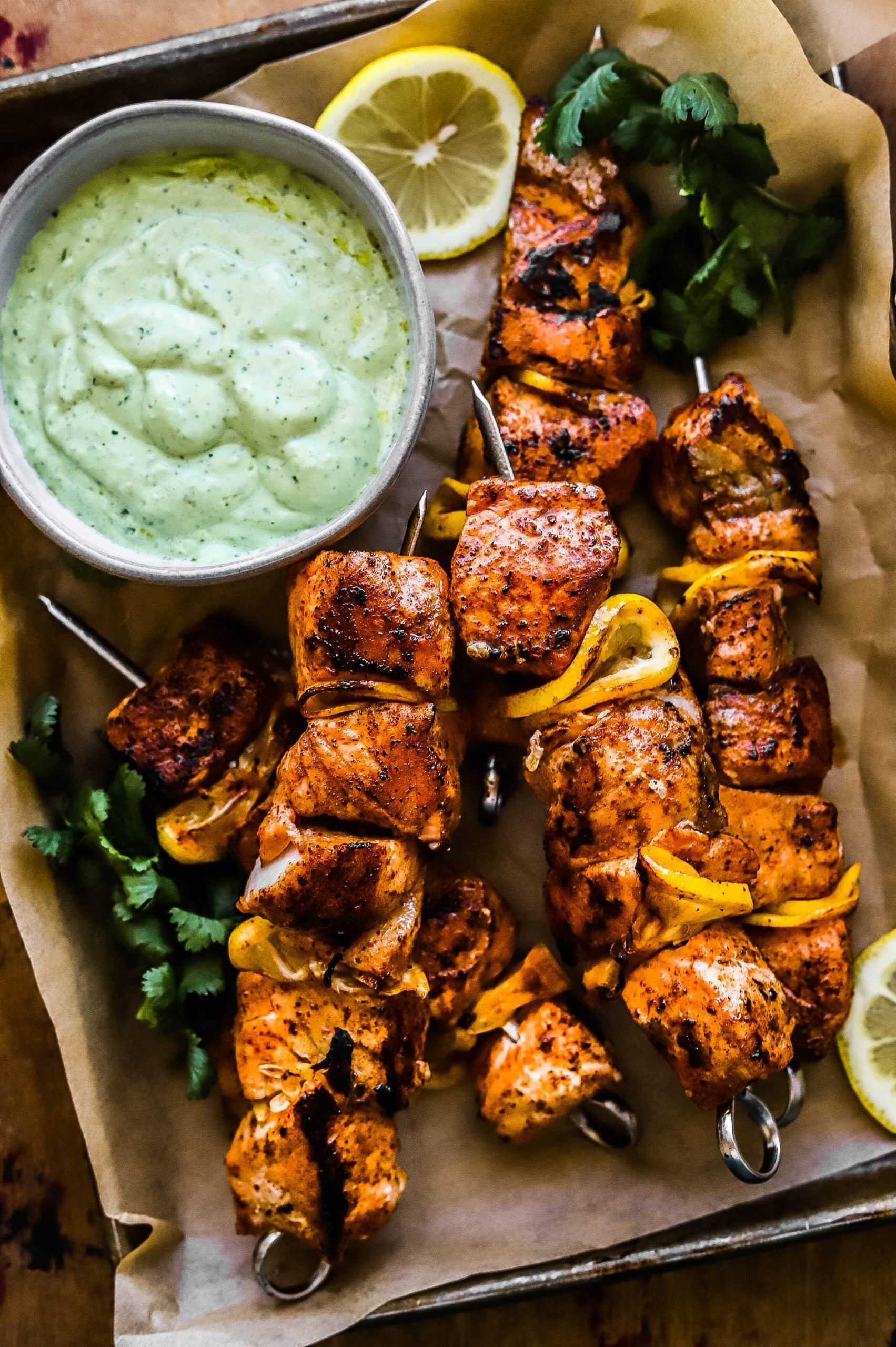grilled salmon skewers with cilantro sauce on parchment paper 