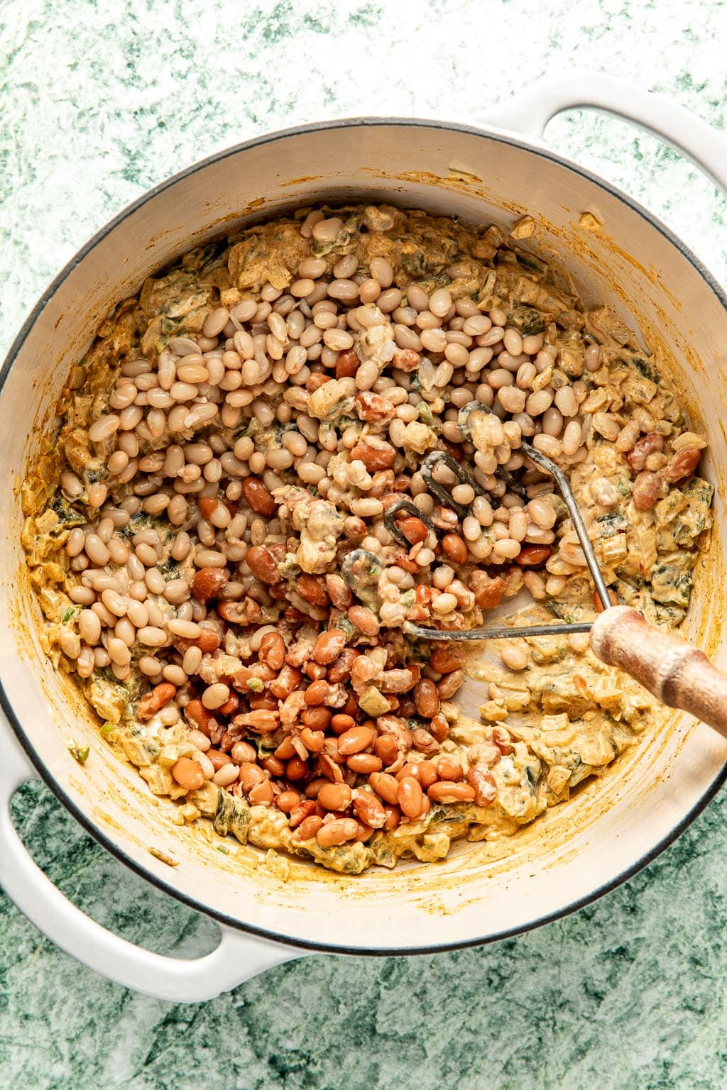 beans being lightly mashed in the white chicken chili