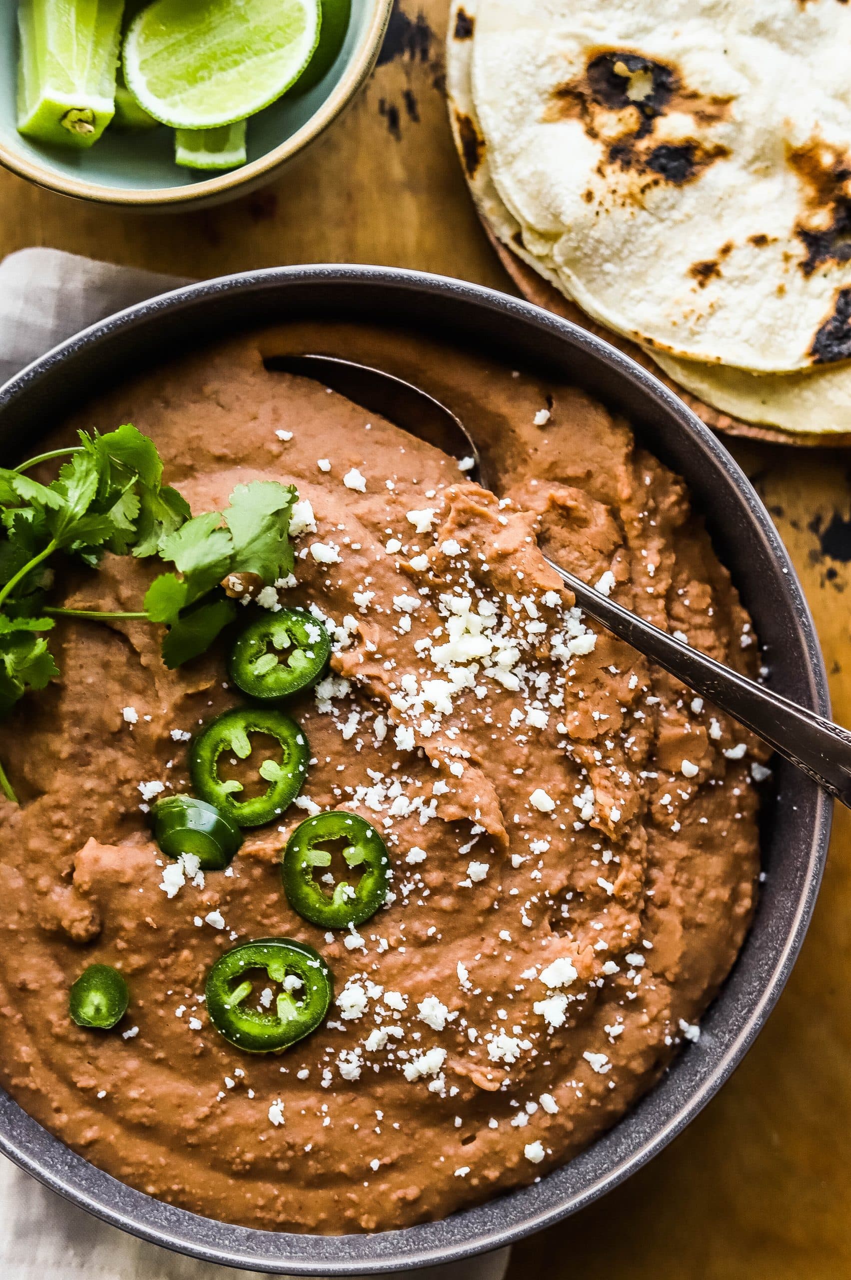 Refried beans garnished with cotija cheese and sliced jalapeño