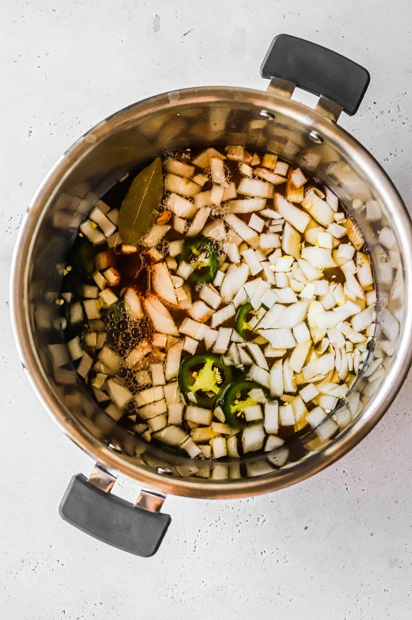 Cooked pinto beans and aromatics in an Instant Pot insert 