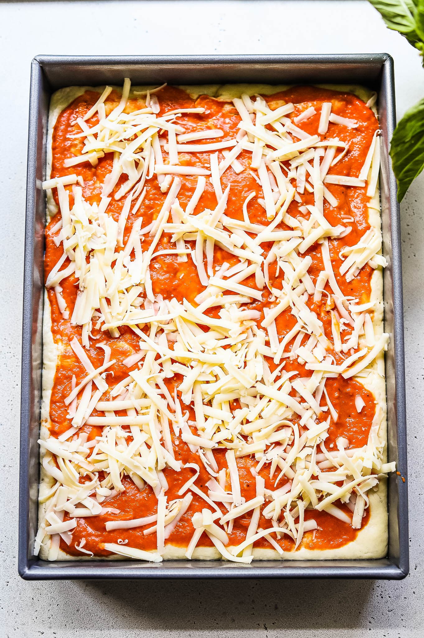 Process shot showing a pizza being assembled