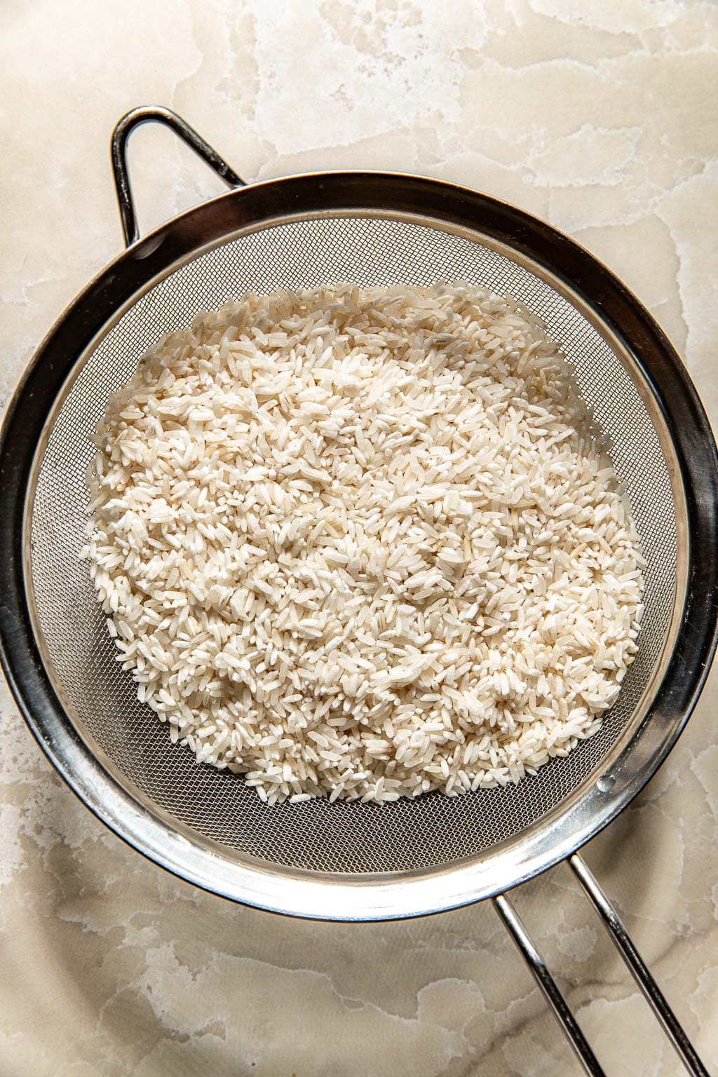 rice sitting in a mesh strainer