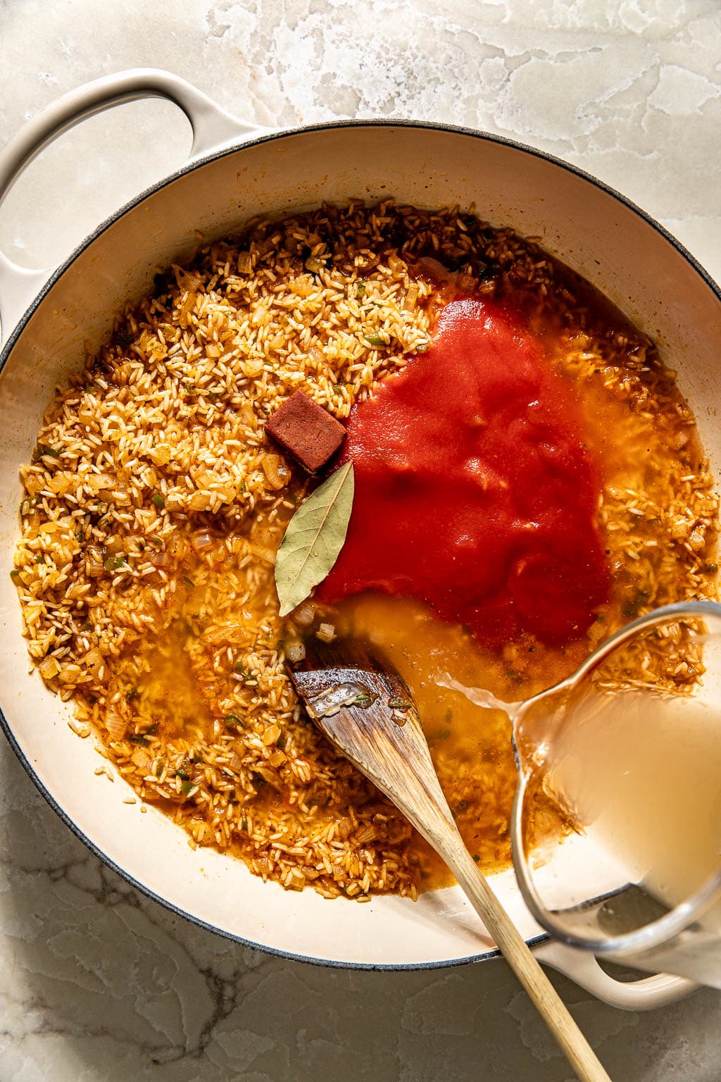 broth and tomato sauce being pored into the rice