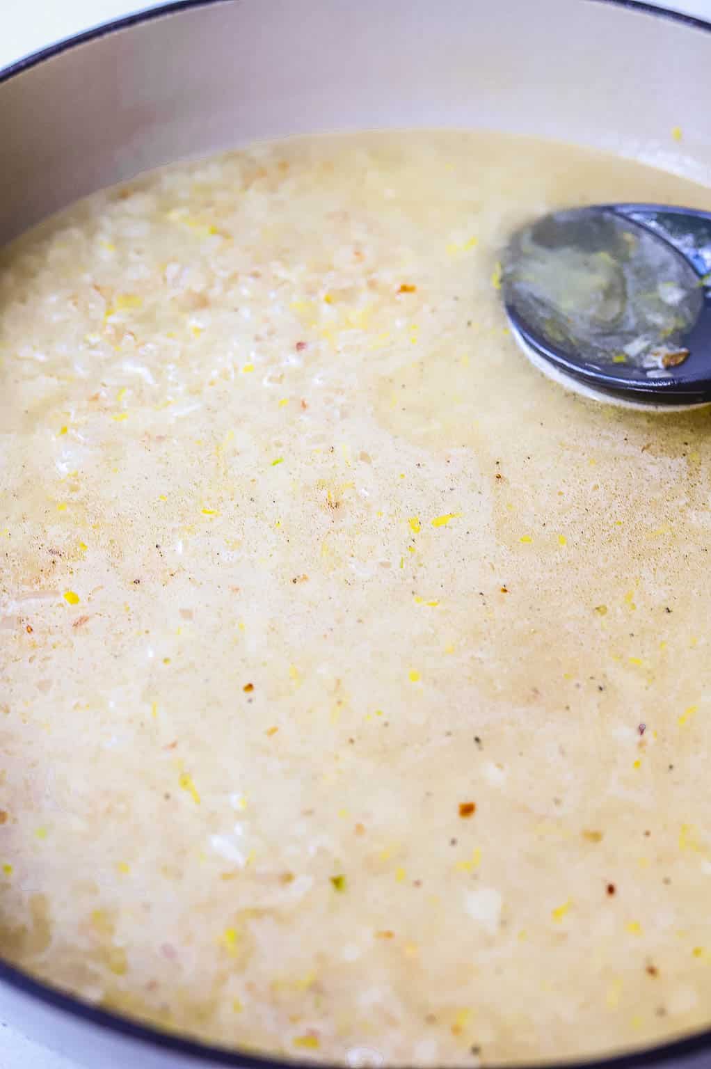 Uncooked rice and broth in a skillet 