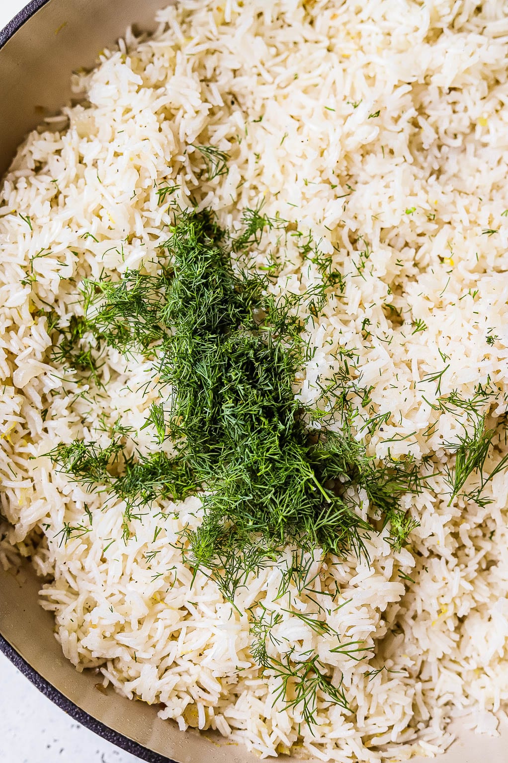Fresh dill added to basmati rice in skillet 