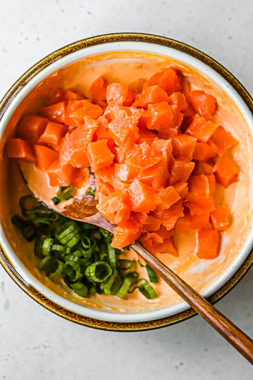 Raw salmon and green onions in spicy mayo