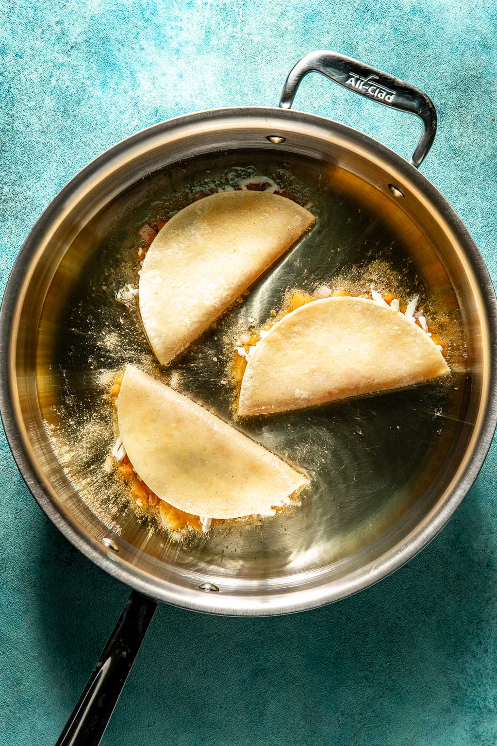 Frying potato tacos in a thin layer of oil