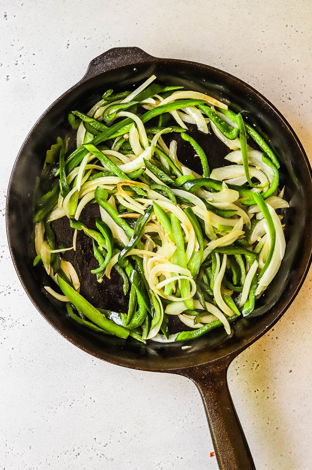 Sautéed peppers and onions in a skillet 