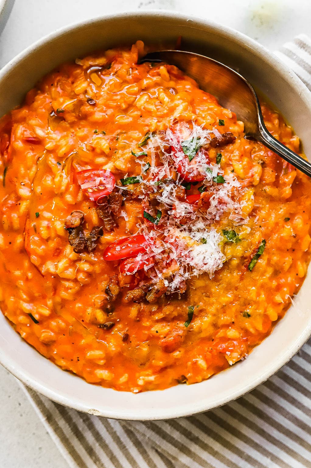 Tomato risotto garnished with cheese and crispy pancetta 