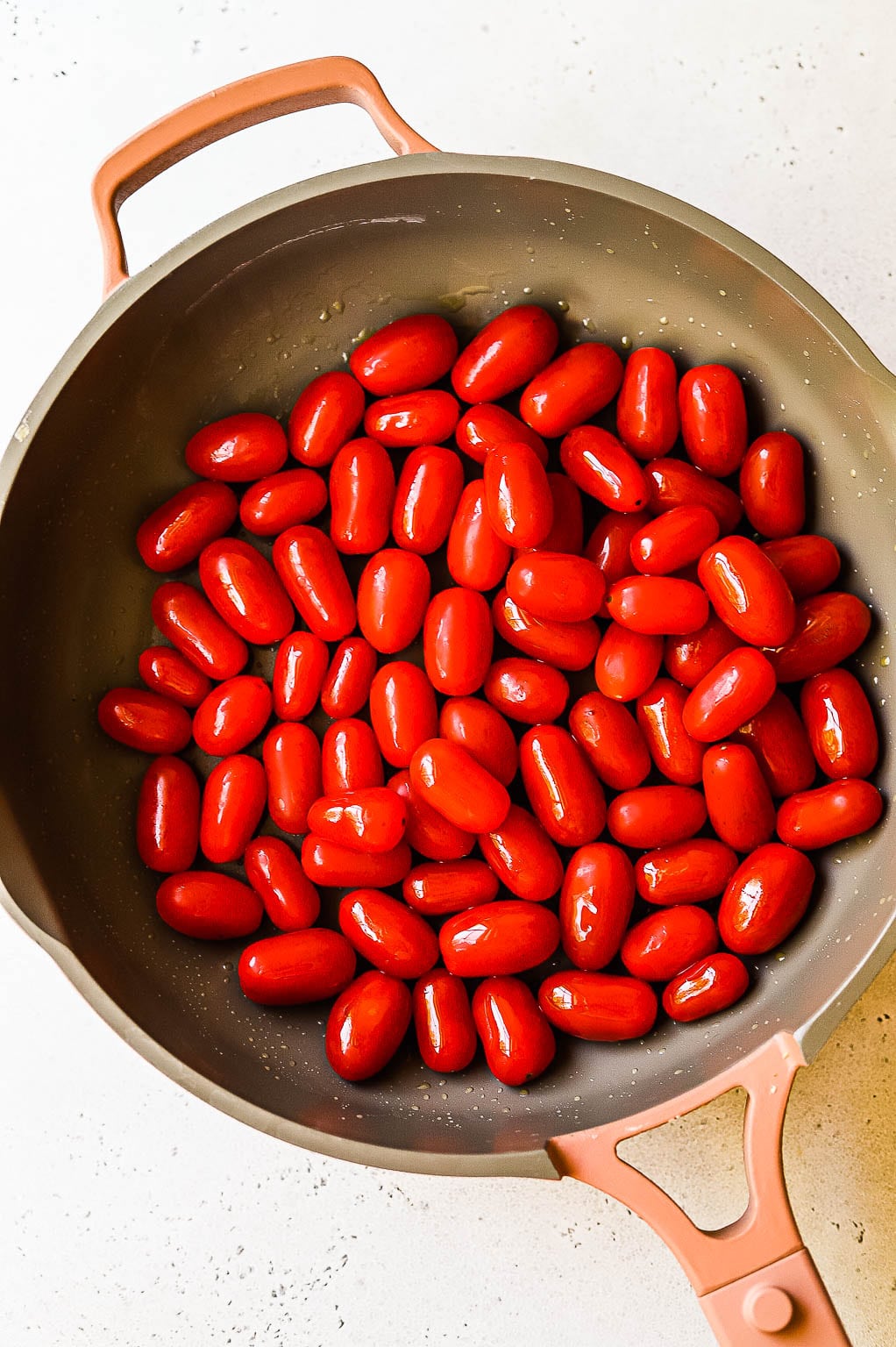 Small tomatoes cooking in a skillet 