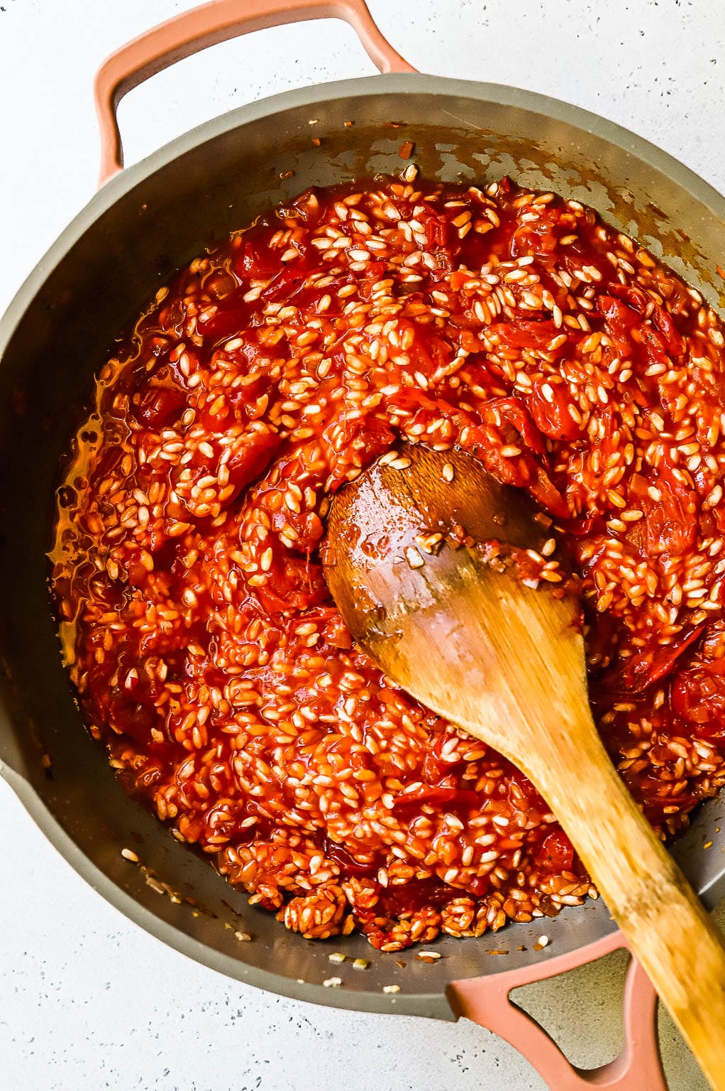 Tomato risotto cooking in a skillet 