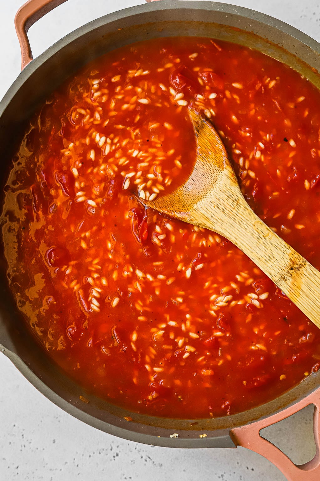 Tomato risotto cooking in a skillet 