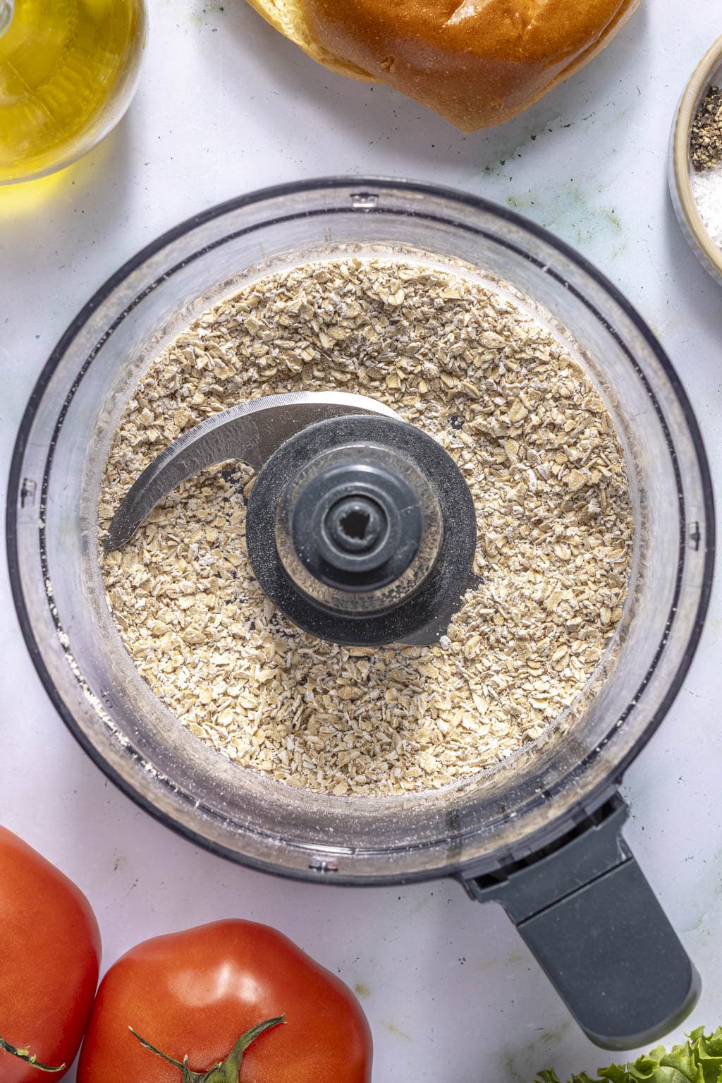 pulsed oats in the bowl of a food processor 