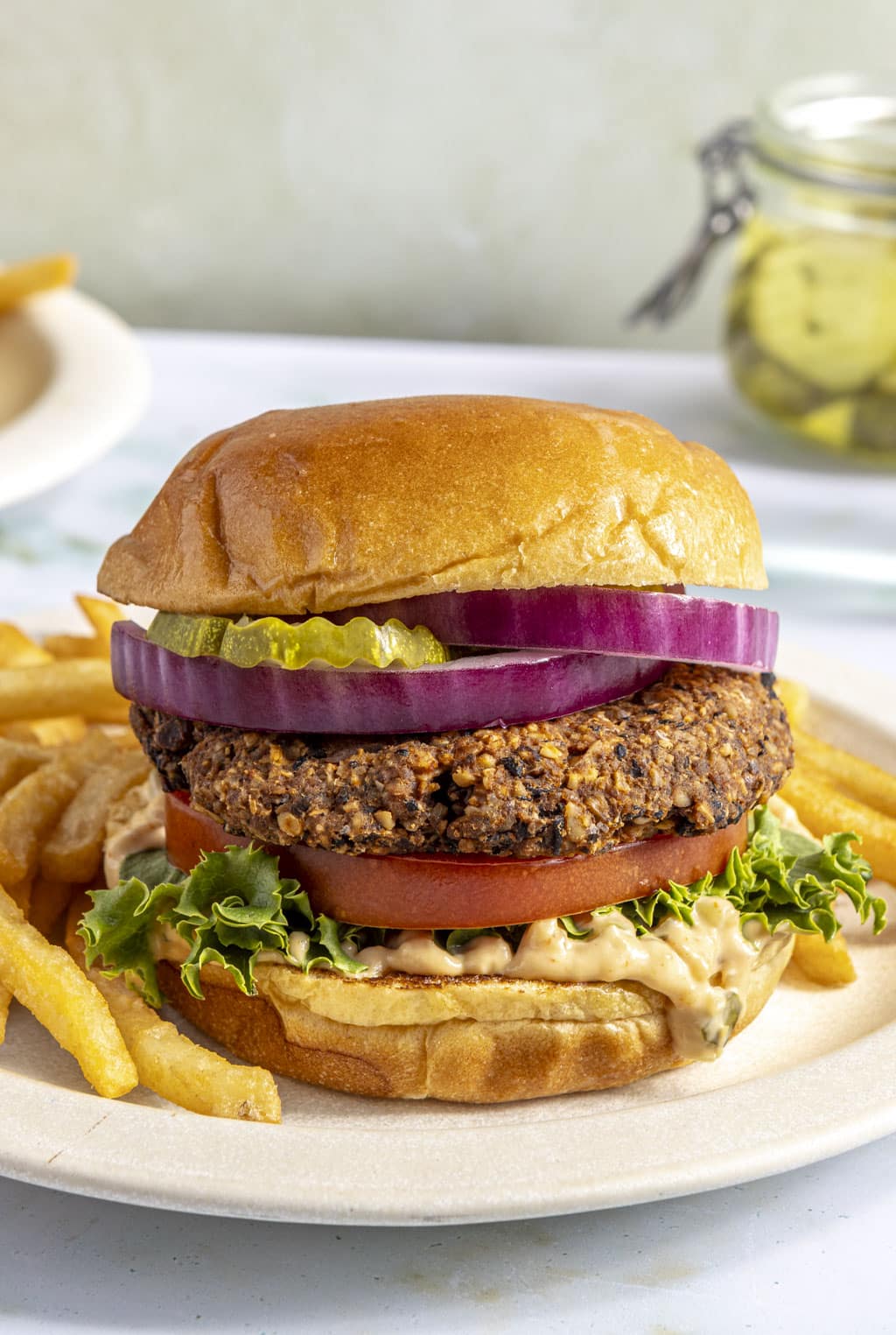 A black bean walnut burger on a plate with fries