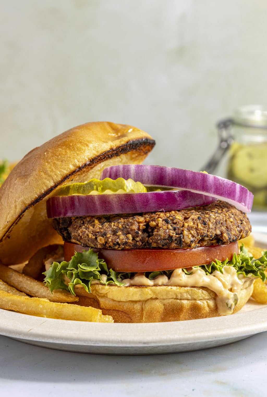 A black bean walnut burger with the top bun tipped to the side 