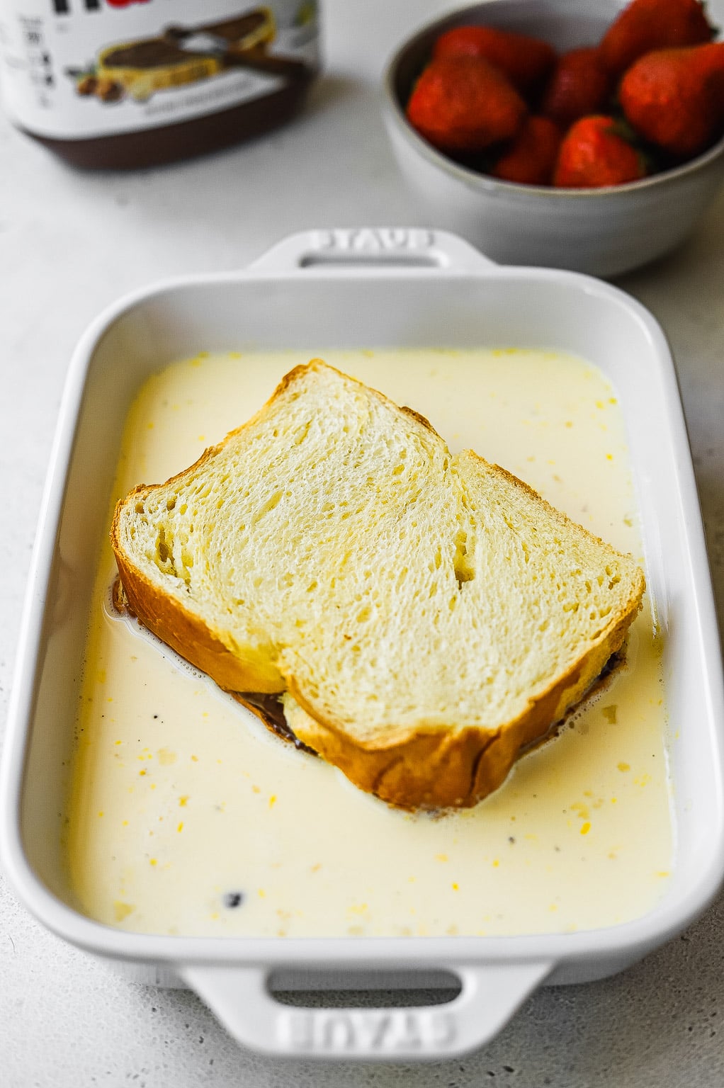 Nutella stuffed brioche bread slices being dunked in custard 