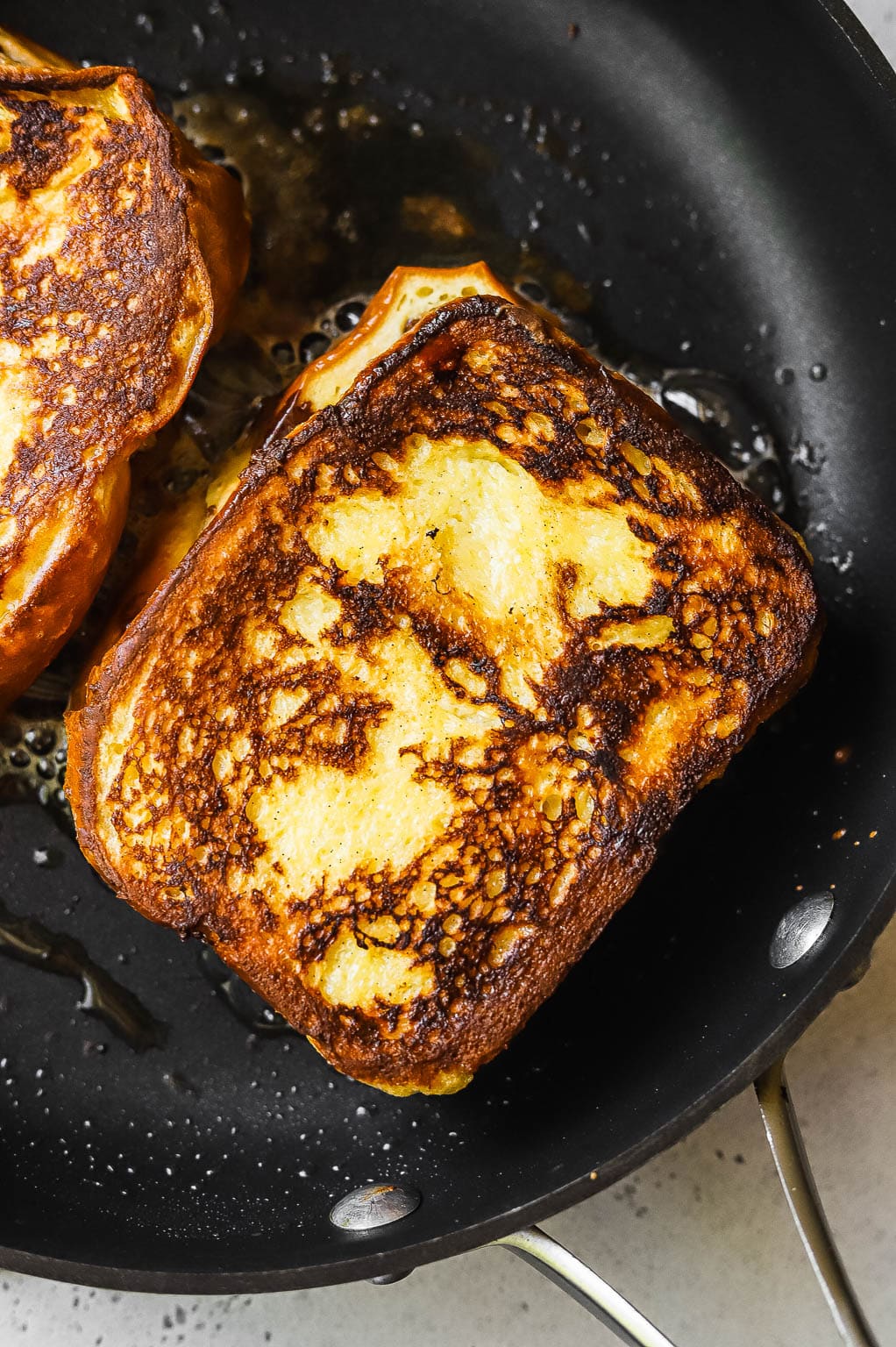 Nutella stuffed brioche bread slices frying in melted butter 