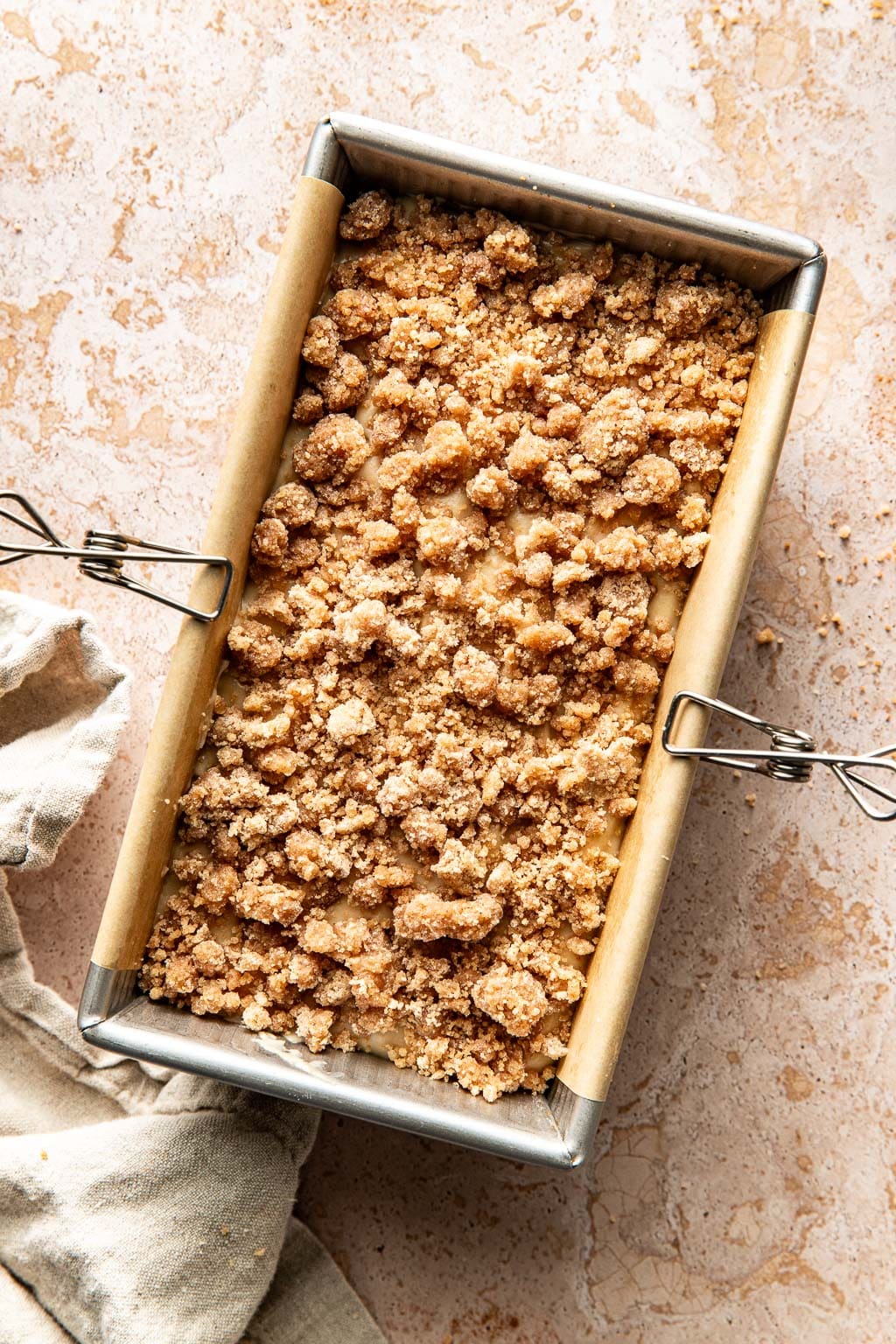 Assembly step showing streusel topping on coffee cake 