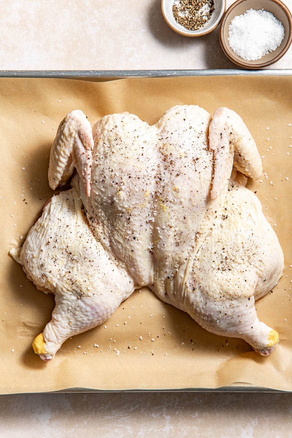 seasoned spatchcocked chicken on a baking sheet