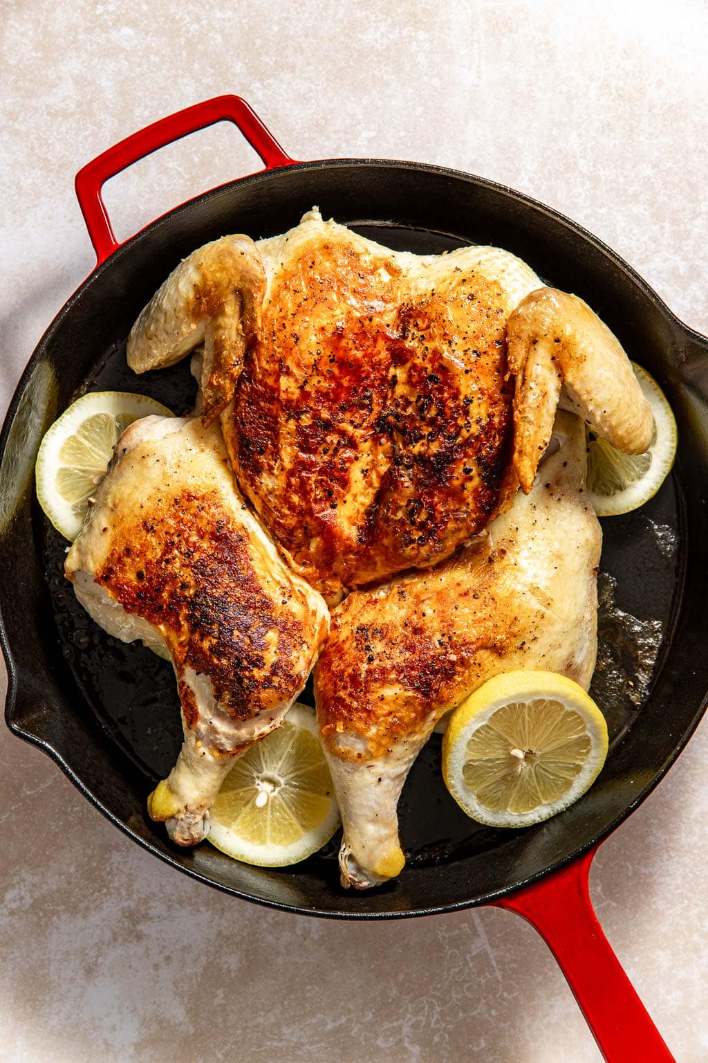 Chicken, skin-side up in a skillet after searing before going into the oven.
