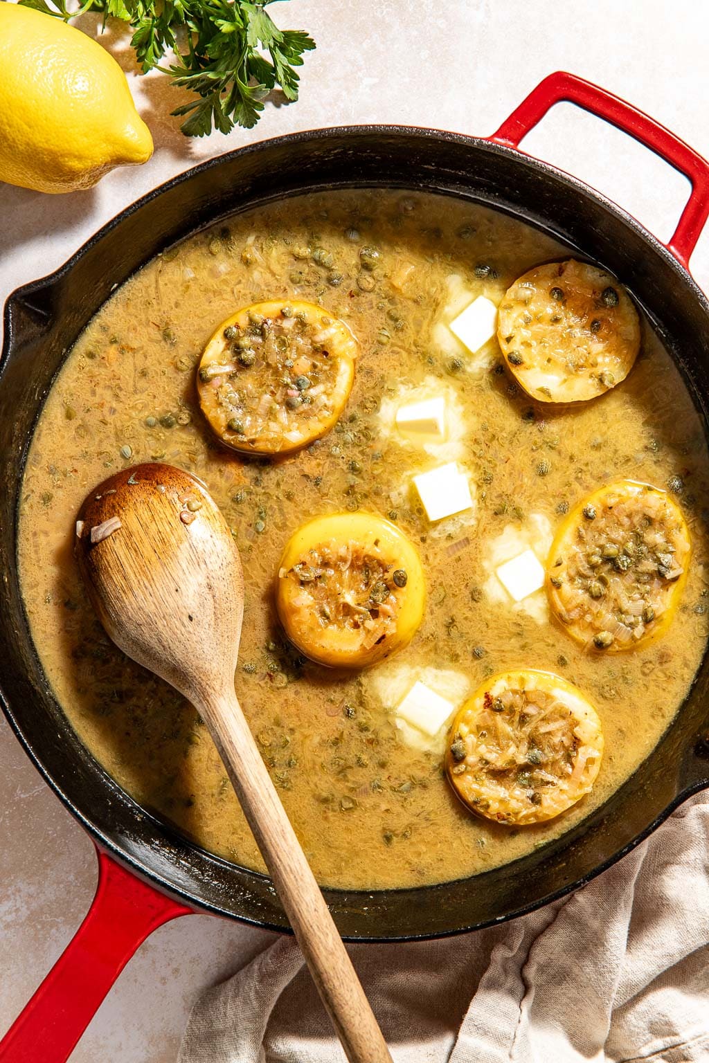 Butter being whisked into piccata sauce in a skillet